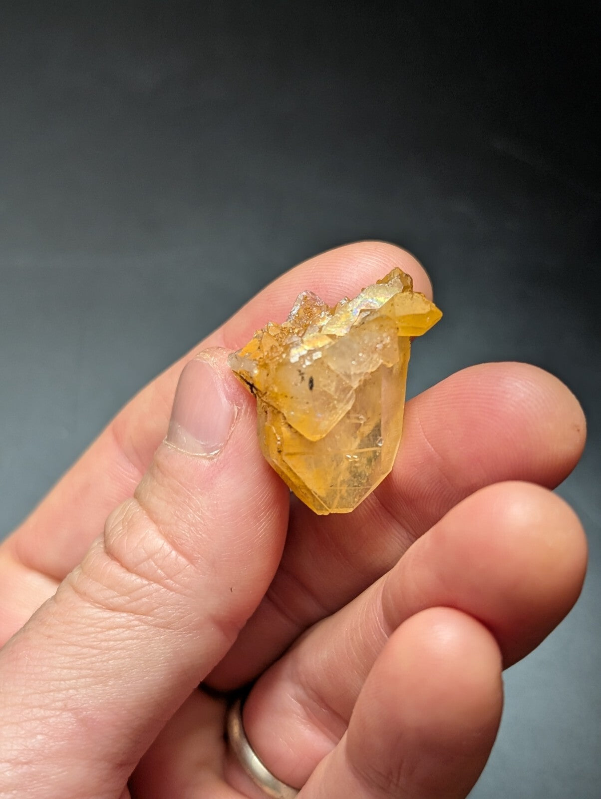 A translucent yellow crystal with a faceted, geometric shape and visible internal inclusions.
