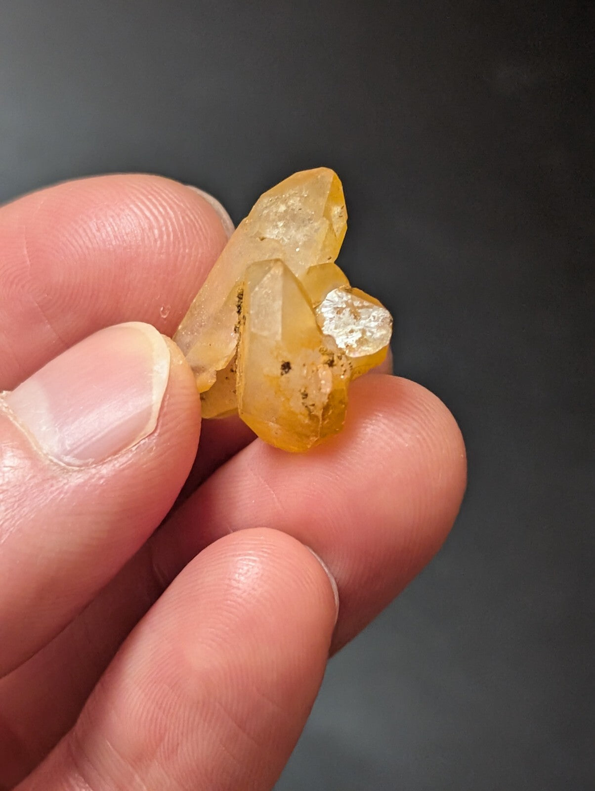 A cluster of translucent yellow crystals with a slightly cloudy, amber hue and visible internal inclusions.