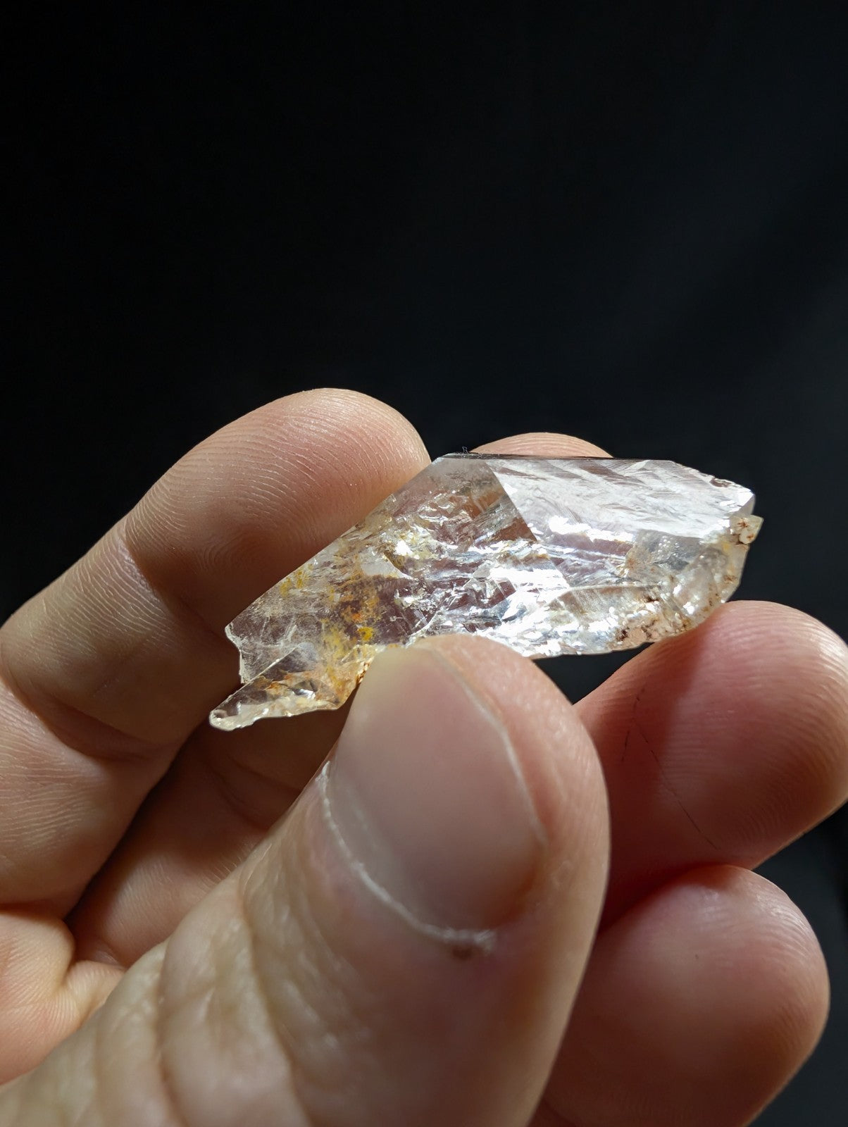 A translucent, faceted quartz crystal with subtle golden inclusions and a natural, irregular shape.