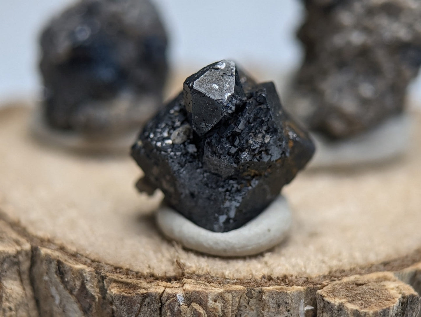 Set of 3 brookite and smoky quartz dark faceted mineral specimens with metallic sheen on wood stand from Arkansas