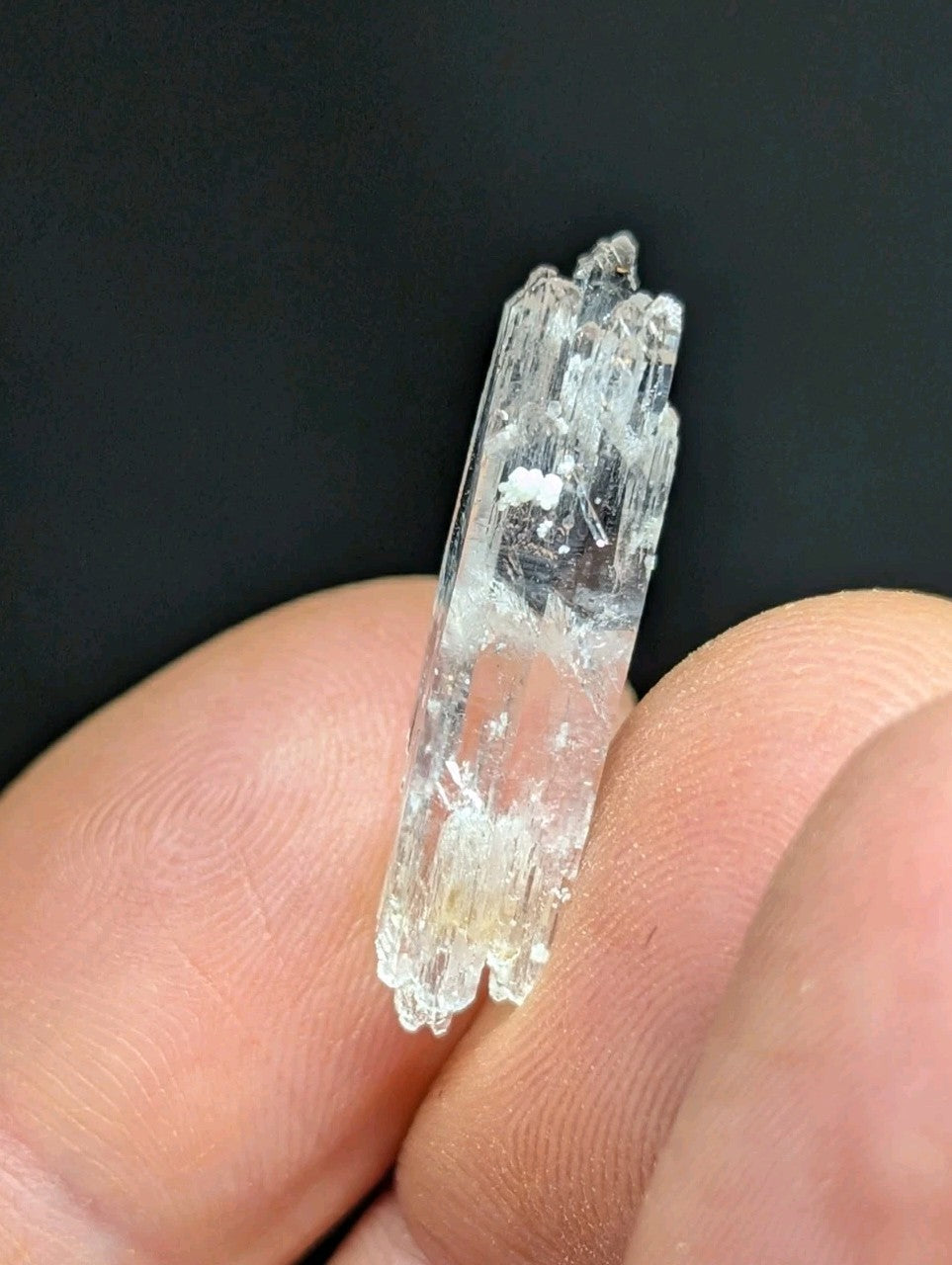 A translucent, clear quartz crystal with a jagged, faceted surface and subtle internal inclusions.