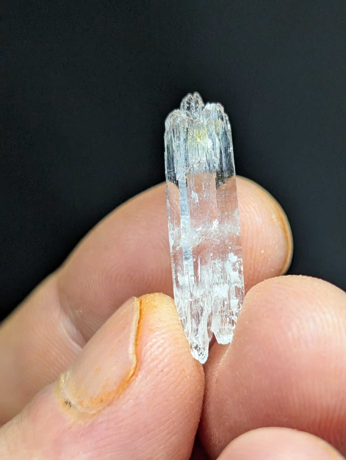 A translucent, clear quartz crystal with a faceted and slightly jagged surface.