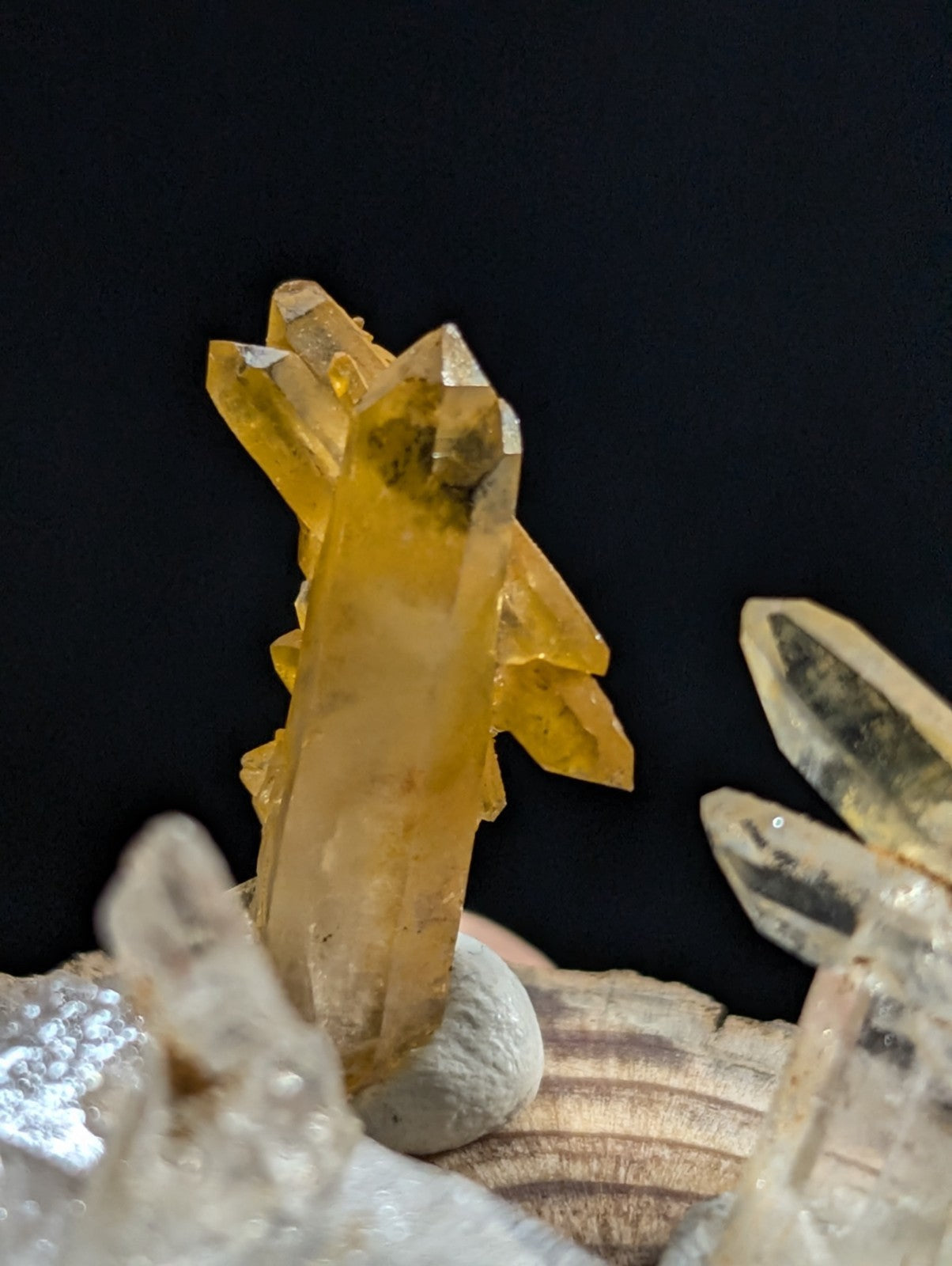 A translucent golden-yellow crystal cluster with sharp, angular facets and a central column surrounded by smaller branching crystals.