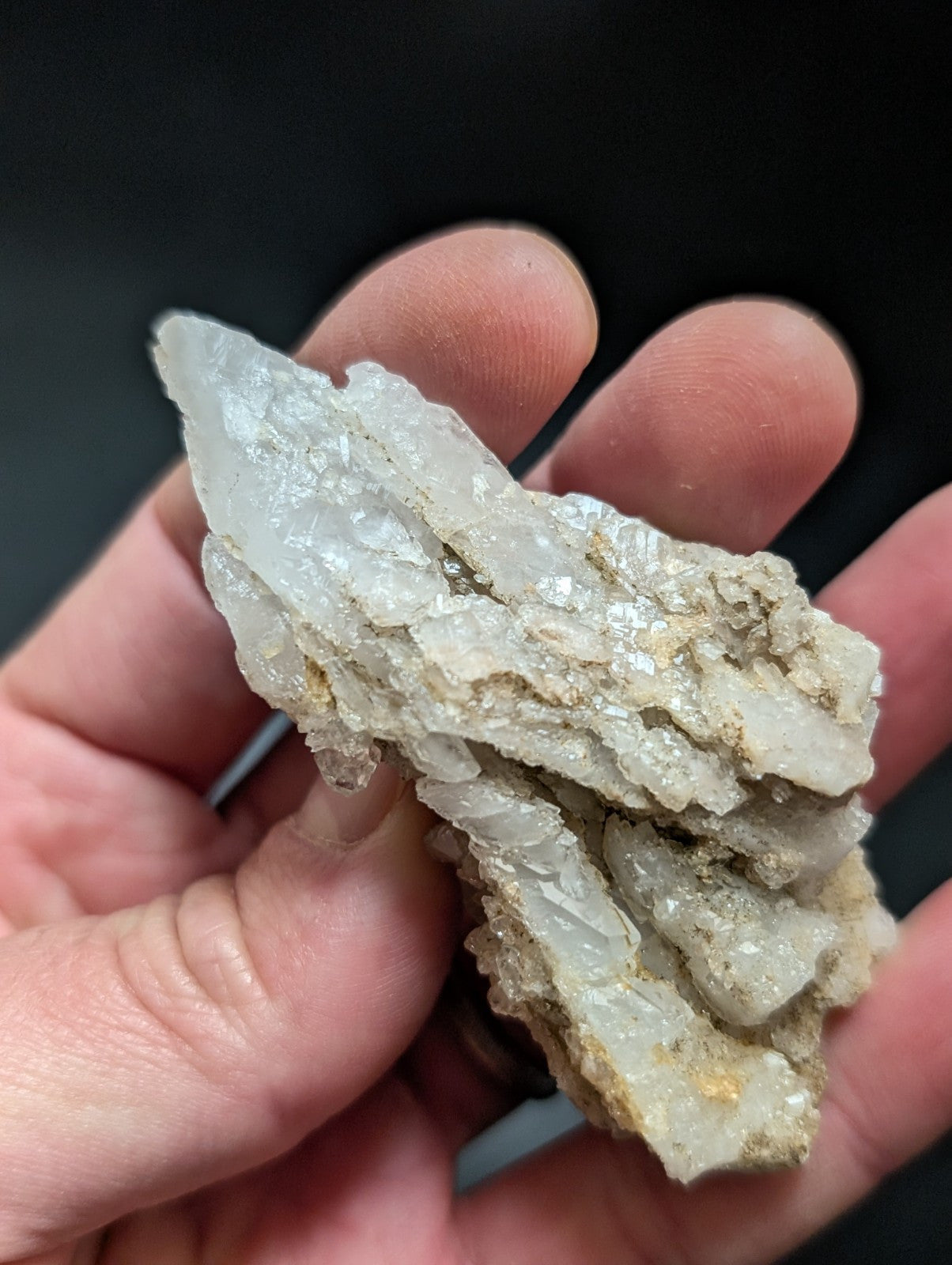A translucent white quartz crystal cluster with jagged, interlocking facets and subtle golden mineral inclusions.