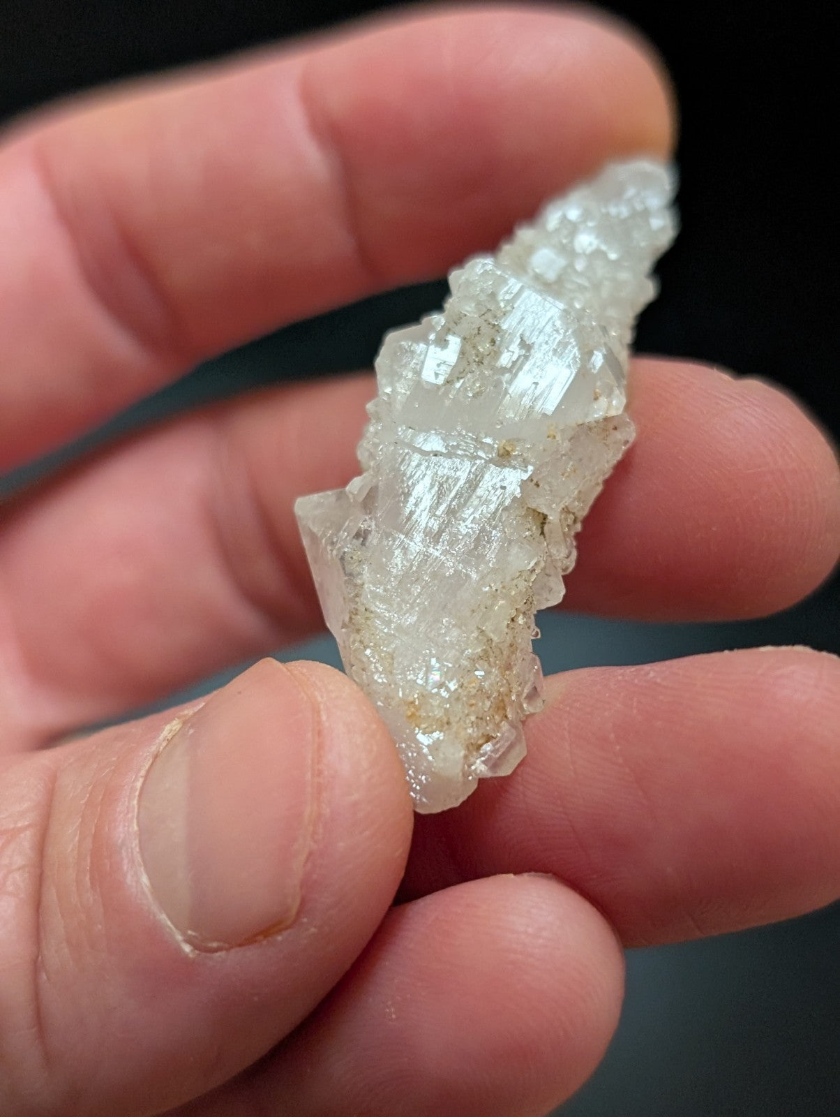 A translucent white crystal cluster with a jagged, faceted surface and subtle golden inclusions.