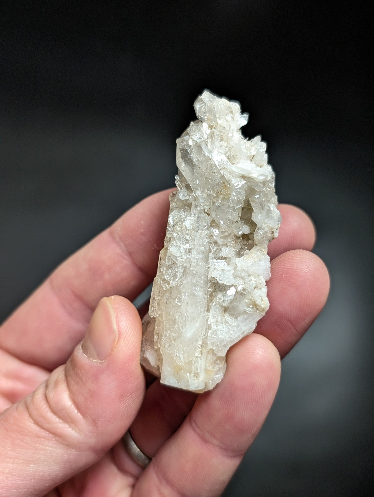 A translucent, crystalline quartz geode specimen with a rough, jagged surface and subtle internal striations.
