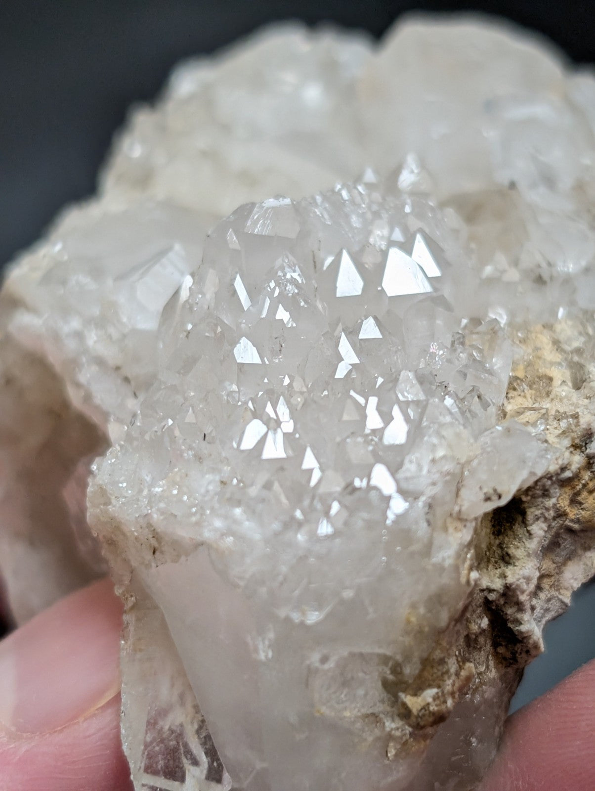 A translucent, crystalline quartz geode with sharp, faceted points and a rough, earthy matrix.