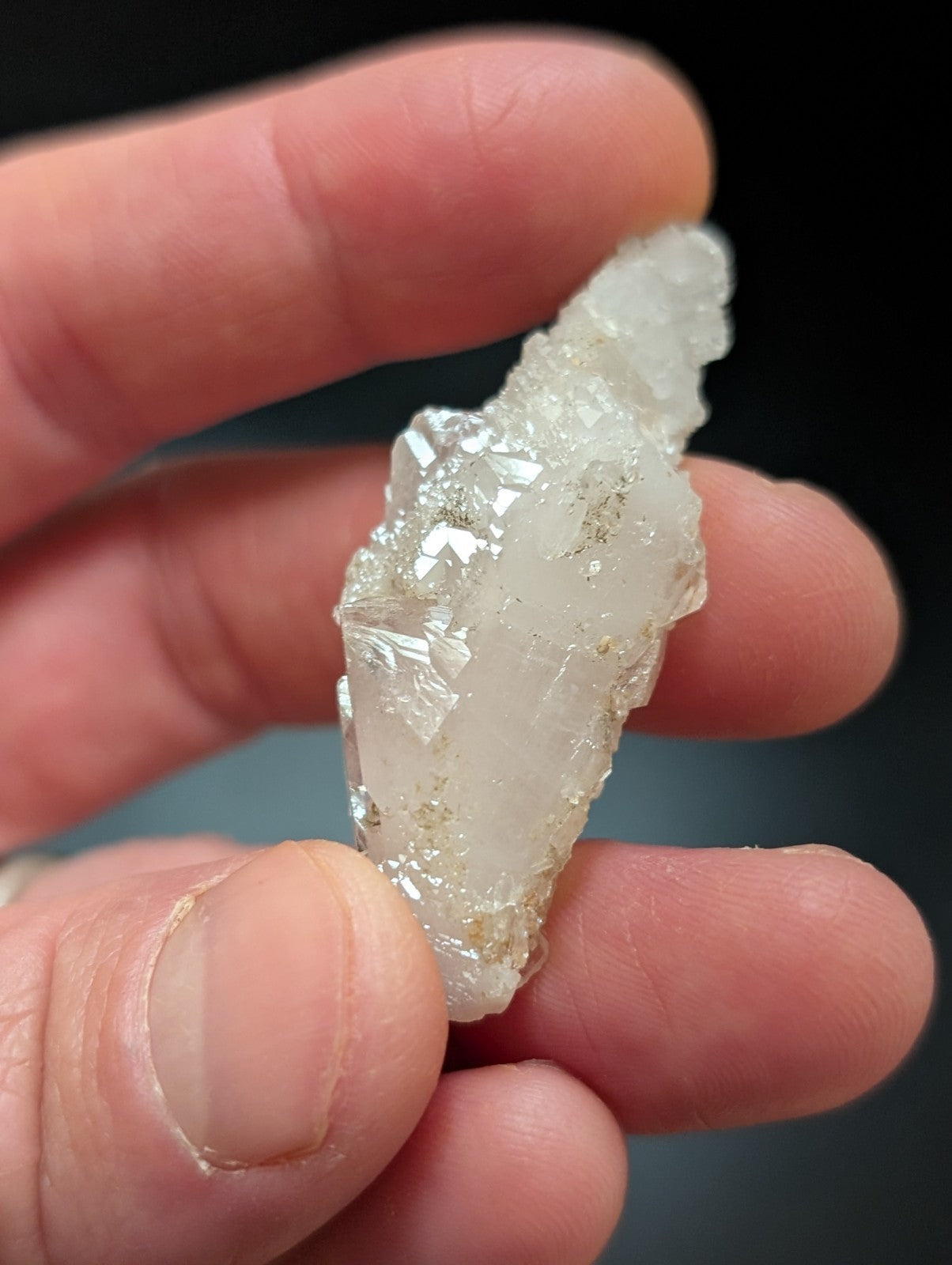 A translucent white quartz crystal cluster with jagged, faceted edges and subtle golden inclusions.