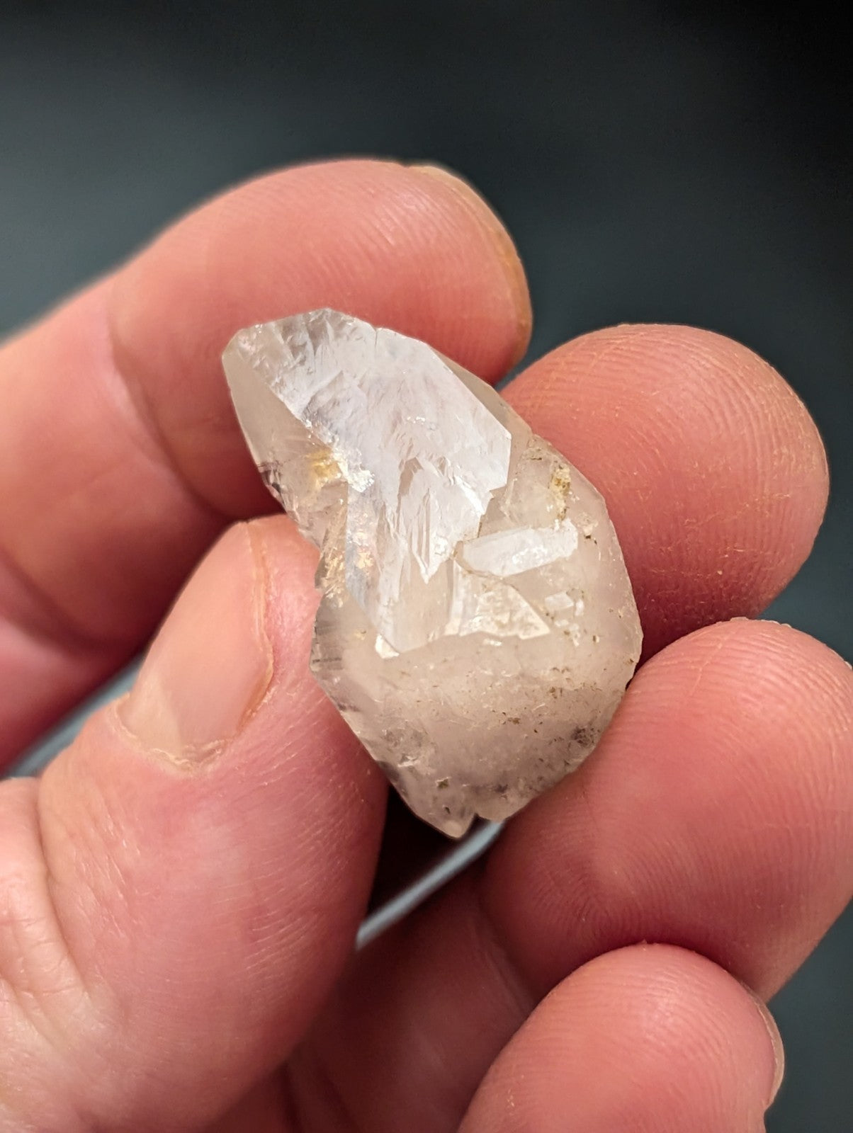 A translucent, clear quartz crystal with natural facets and subtle golden inclusions.
