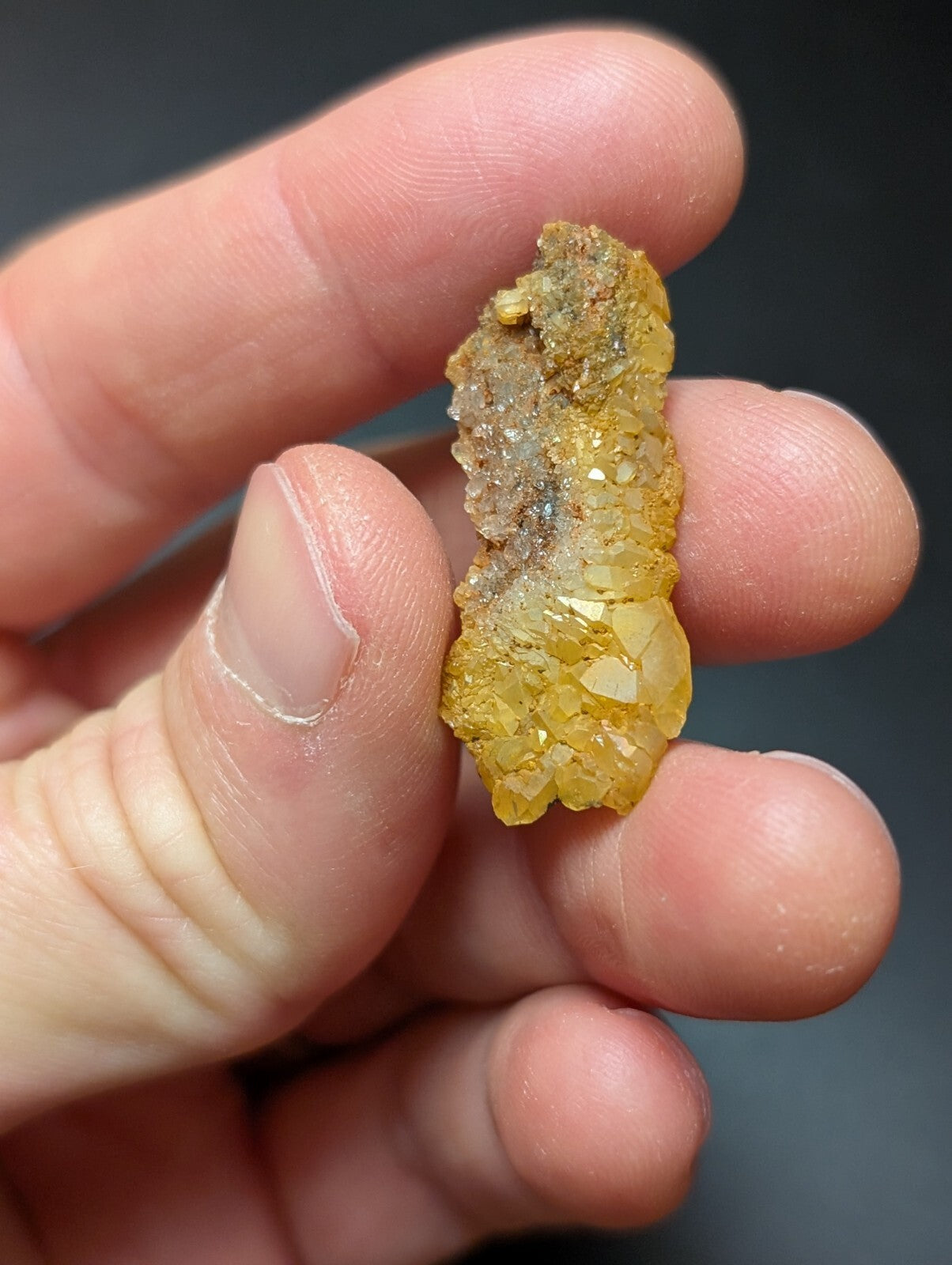 A golden-yellow mineral specimen with crystalline facets and earthy, rough-textured patches.