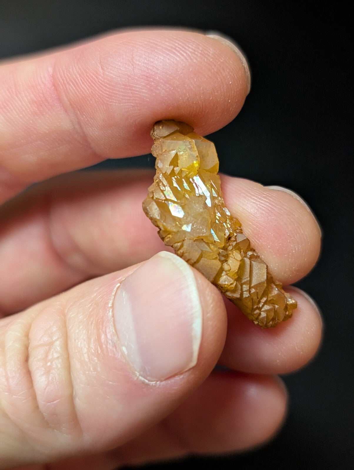 A translucent amber-colored crystal with a rough, faceted surface and visible internal inclusions.