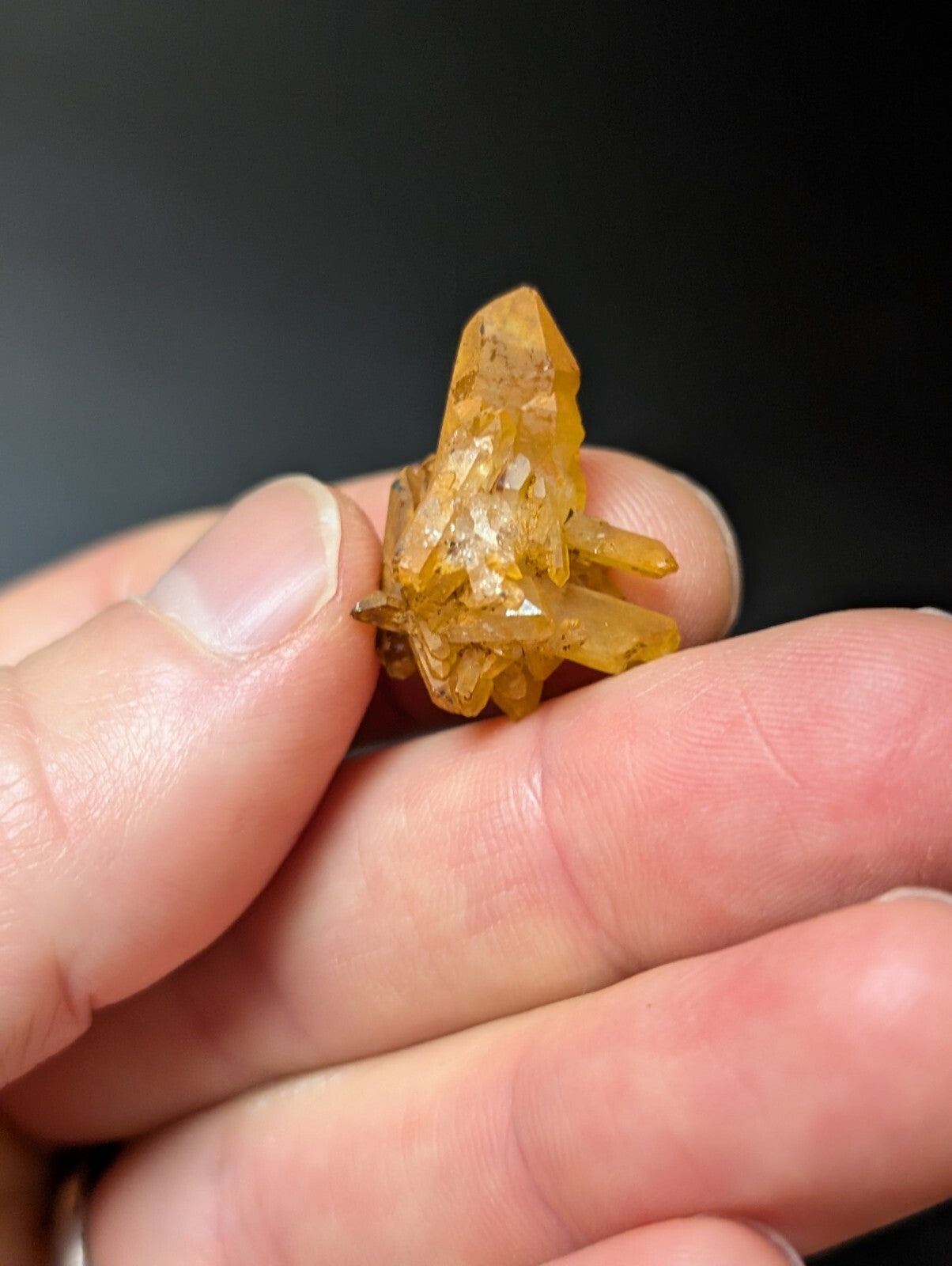 A translucent golden-yellow crystal cluster with sharp, faceted points and a natural, earthy texture.