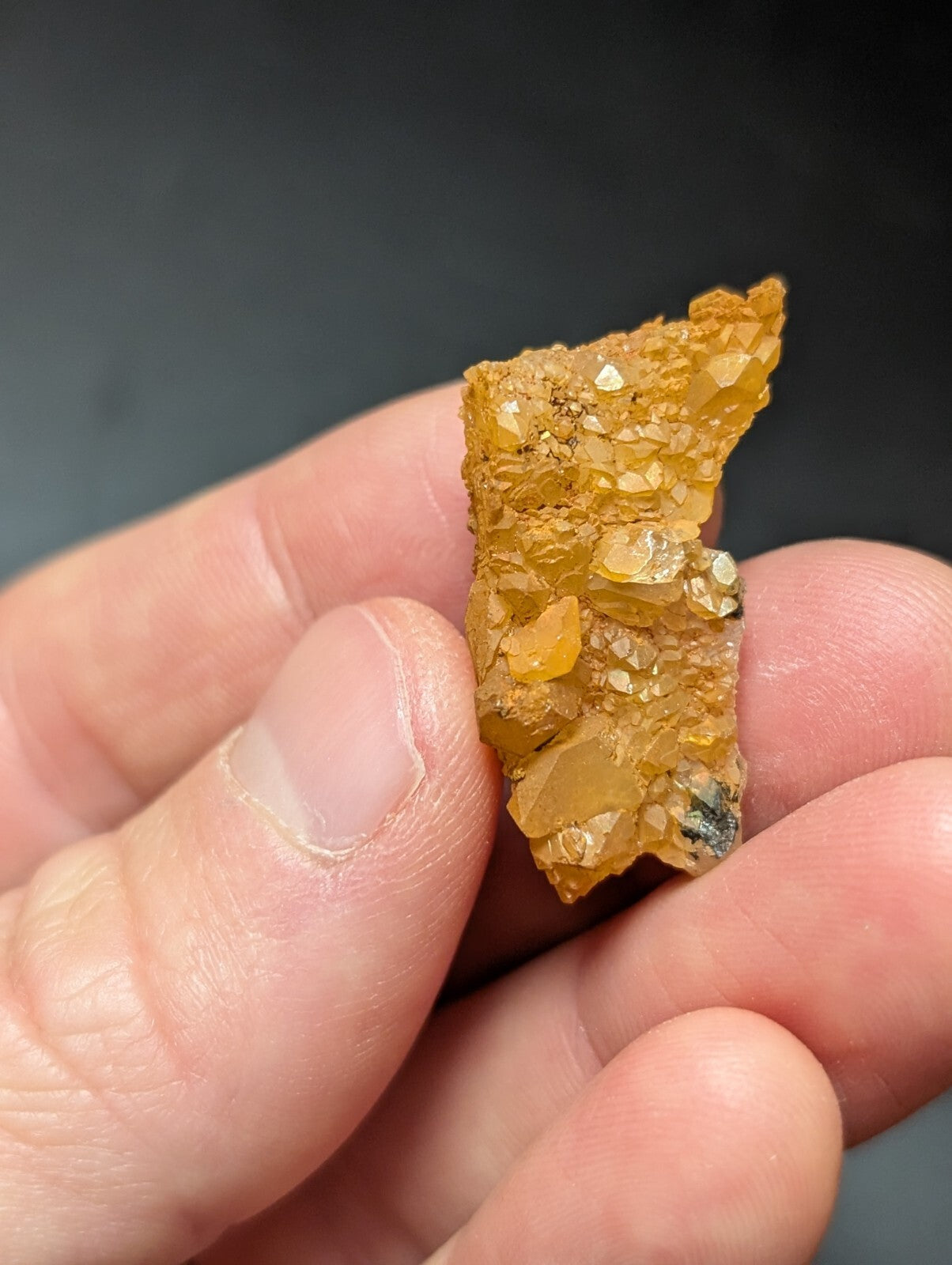 A golden-yellow, translucent mineral specimen with crystalline facets and a rough, jagged surface.