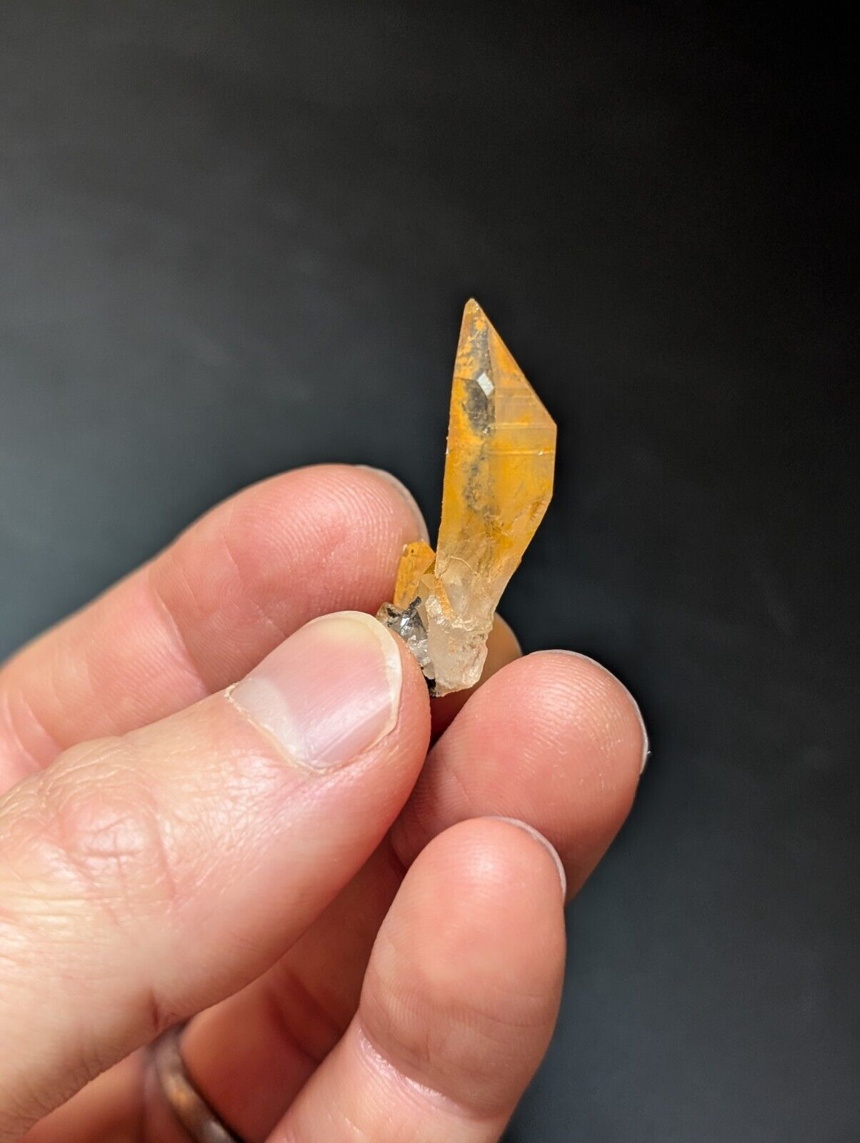 Orange crystal held in hand.