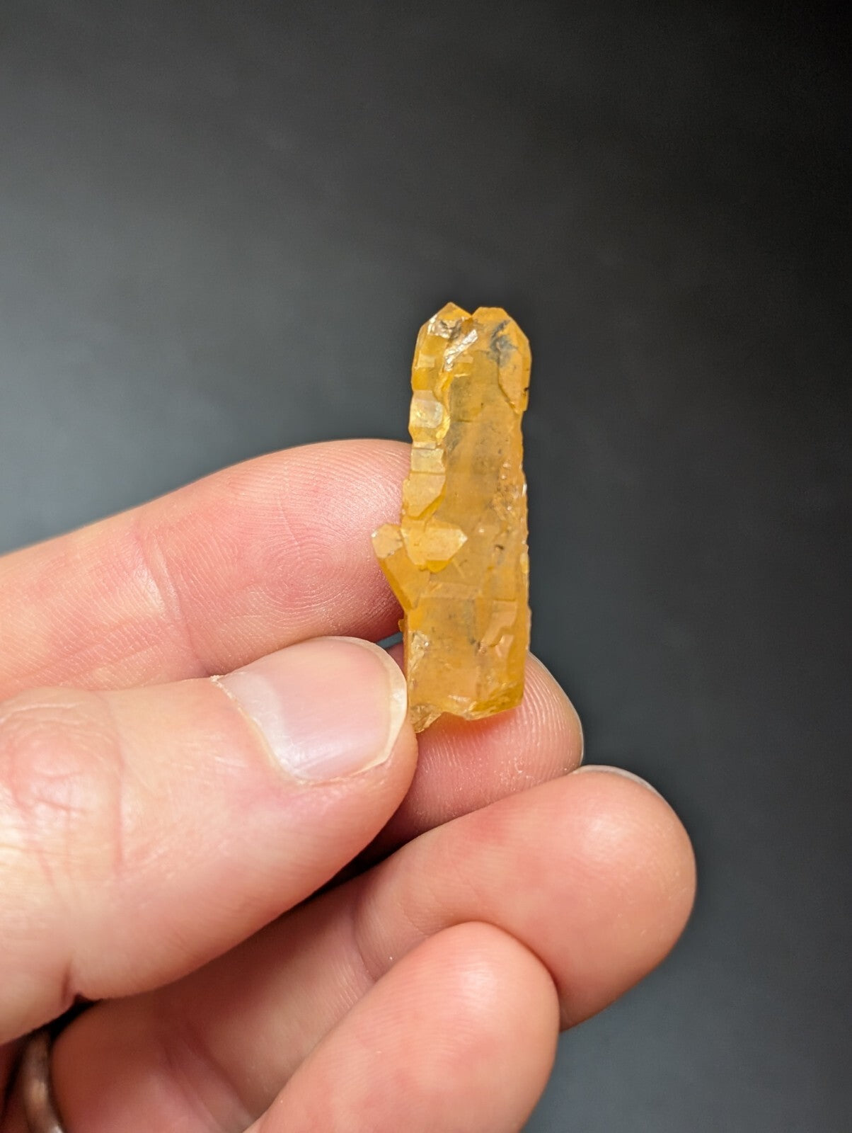 A translucent amber-colored crystal with a jagged, natural formation and visible internal inclusions.