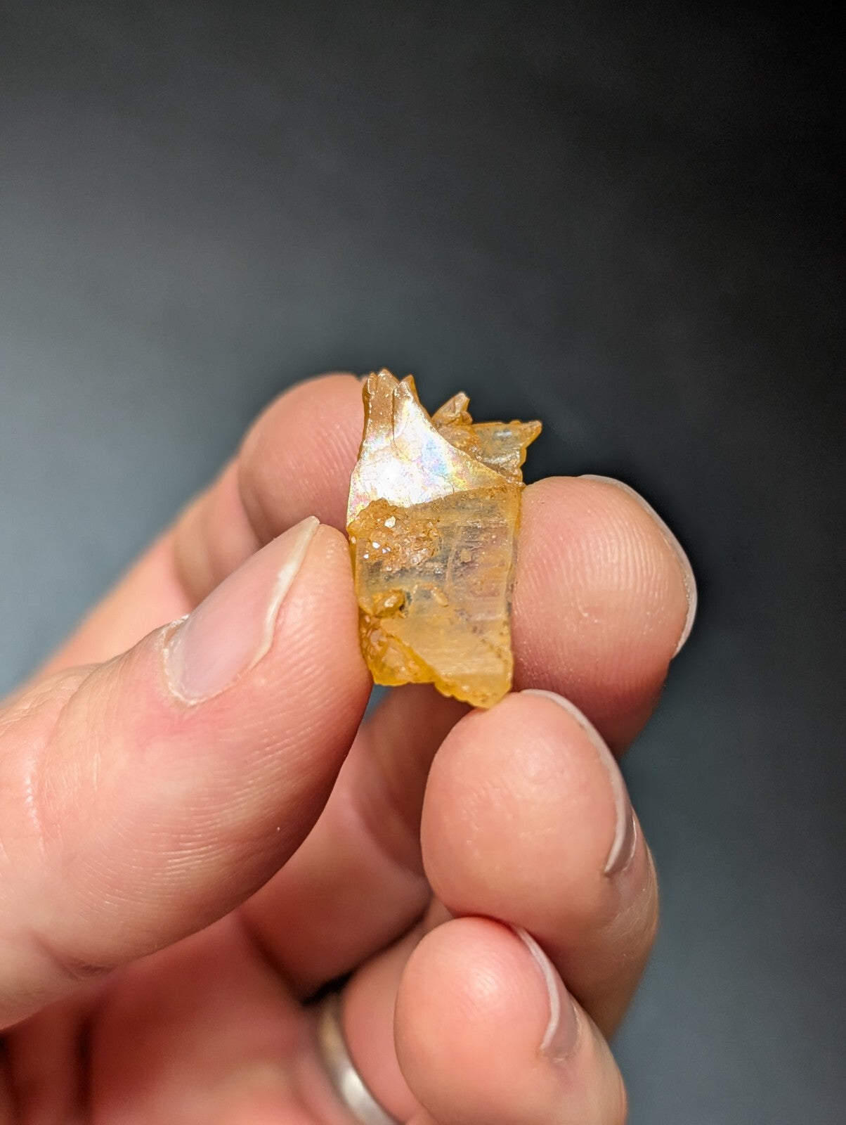 A translucent amber-colored crystal fragment with a rough, jagged surface and subtle internal inclusions.