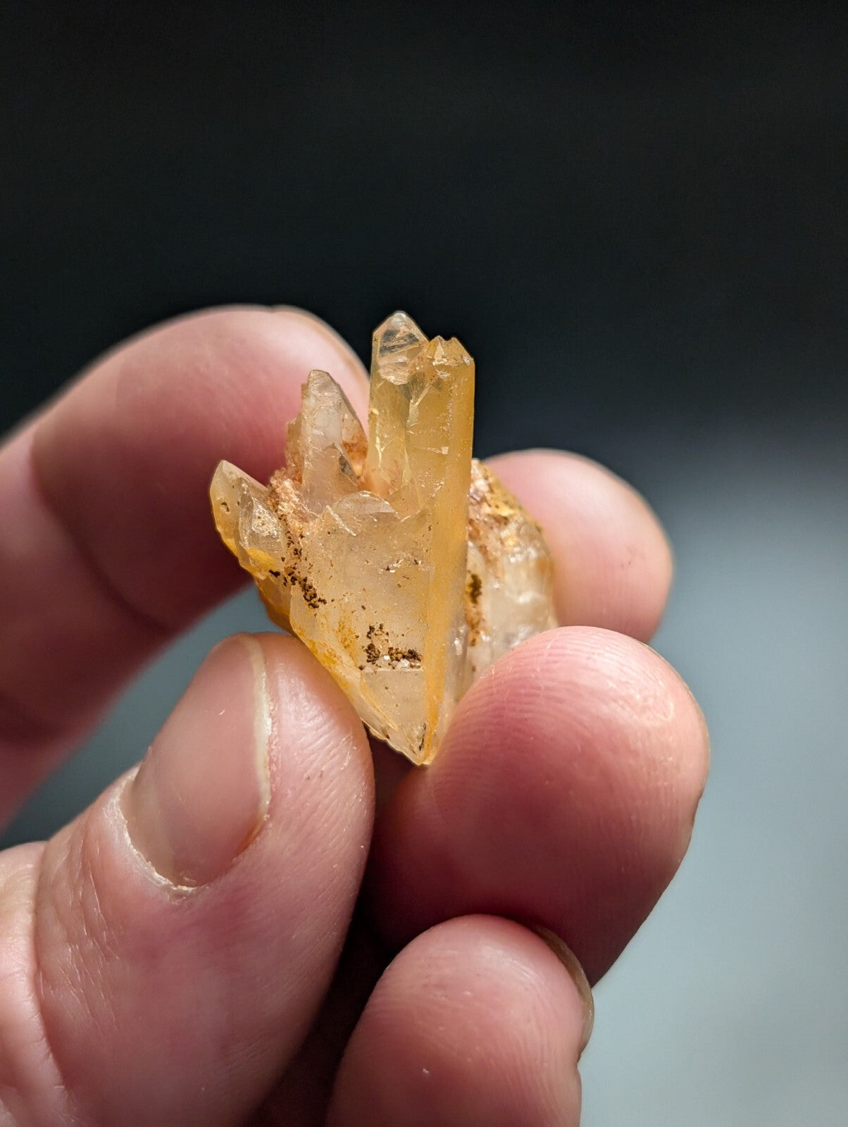 A translucent yellow crystal cluster with sharp, pointed facets and subtle brown inclusions.