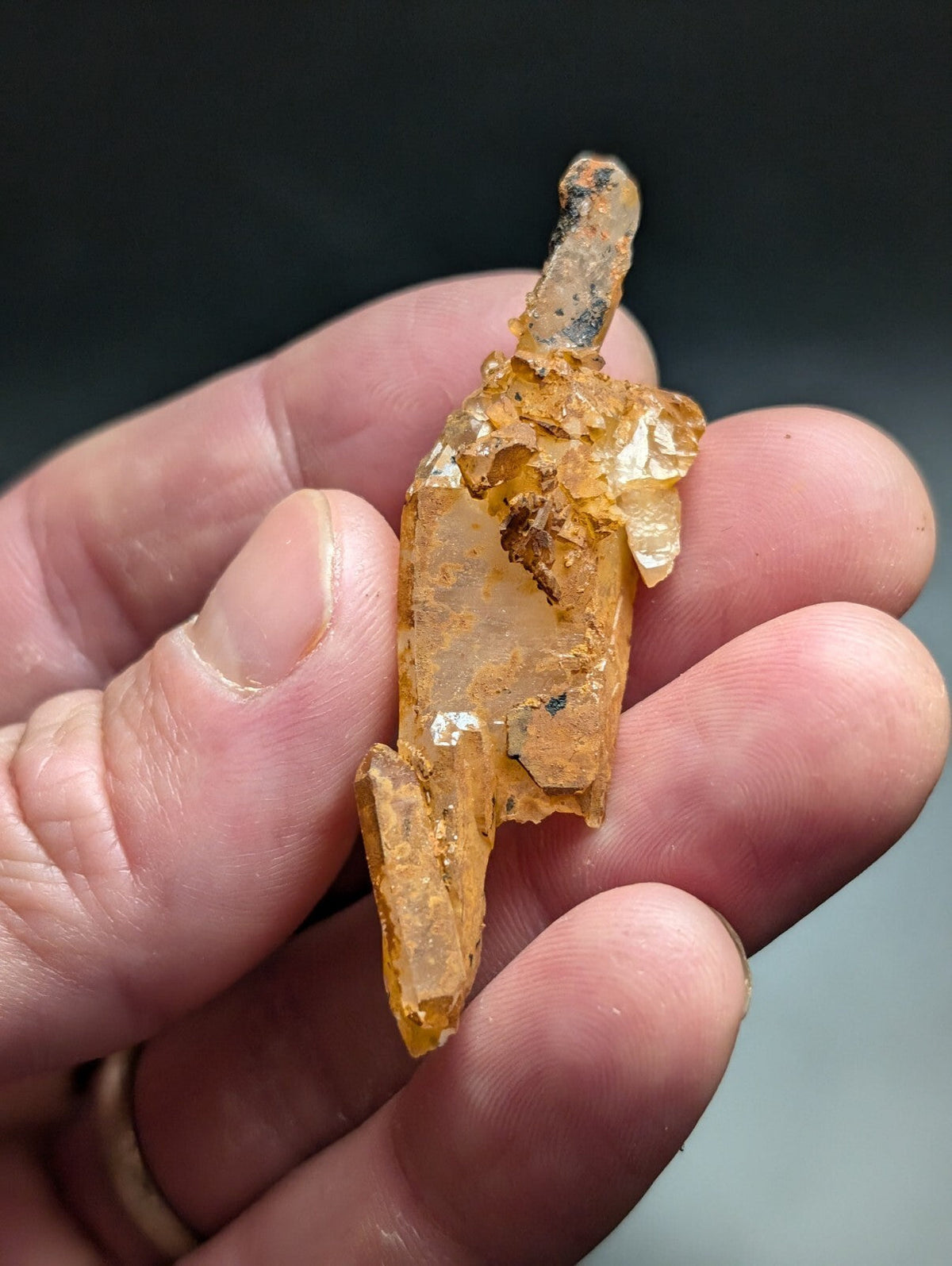 A translucent amber-colored crystal with a rough, jagged surface and visible internal inclusions.