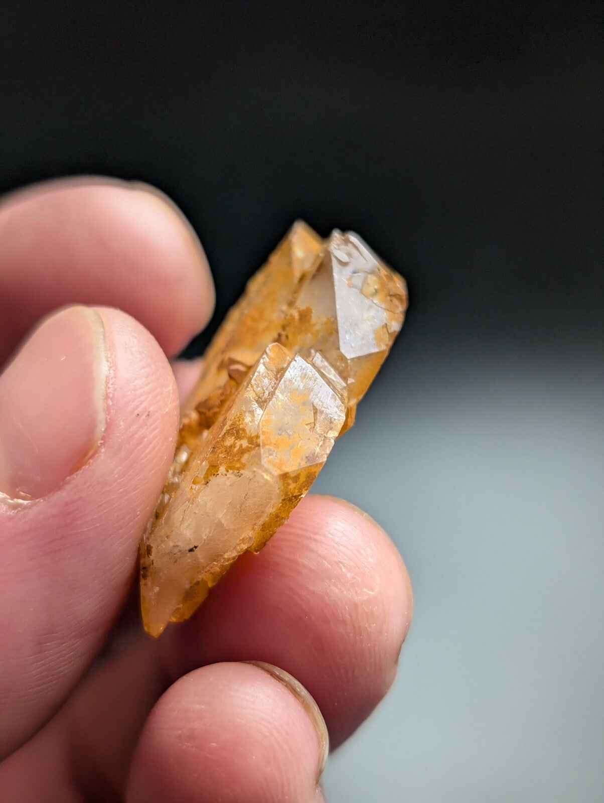 A translucent amber-colored crystal with a faceted, geometric shape and natural inclusions.