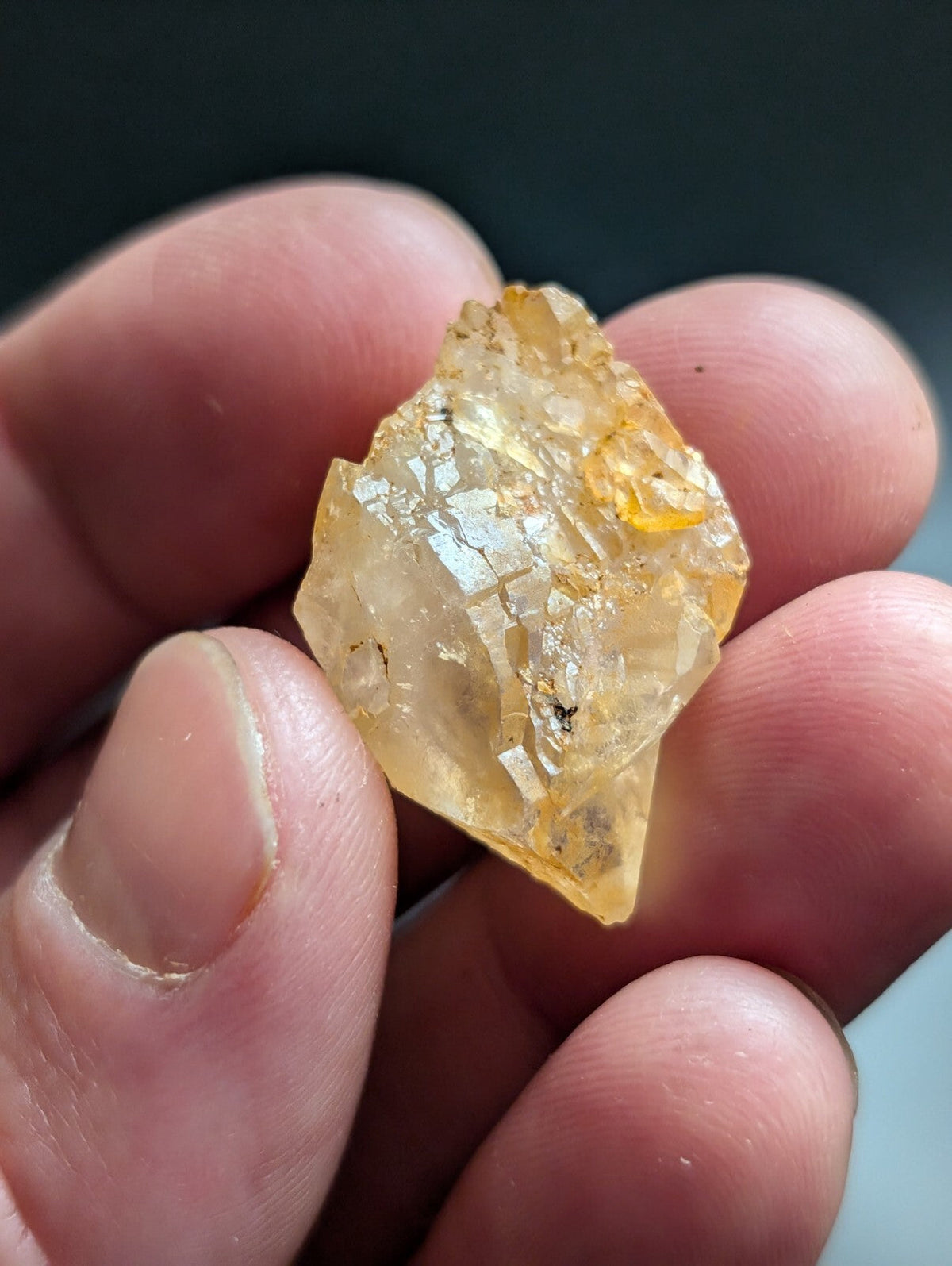 A translucent yellow crystal with a faceted, irregular shape and visible internal inclusions.