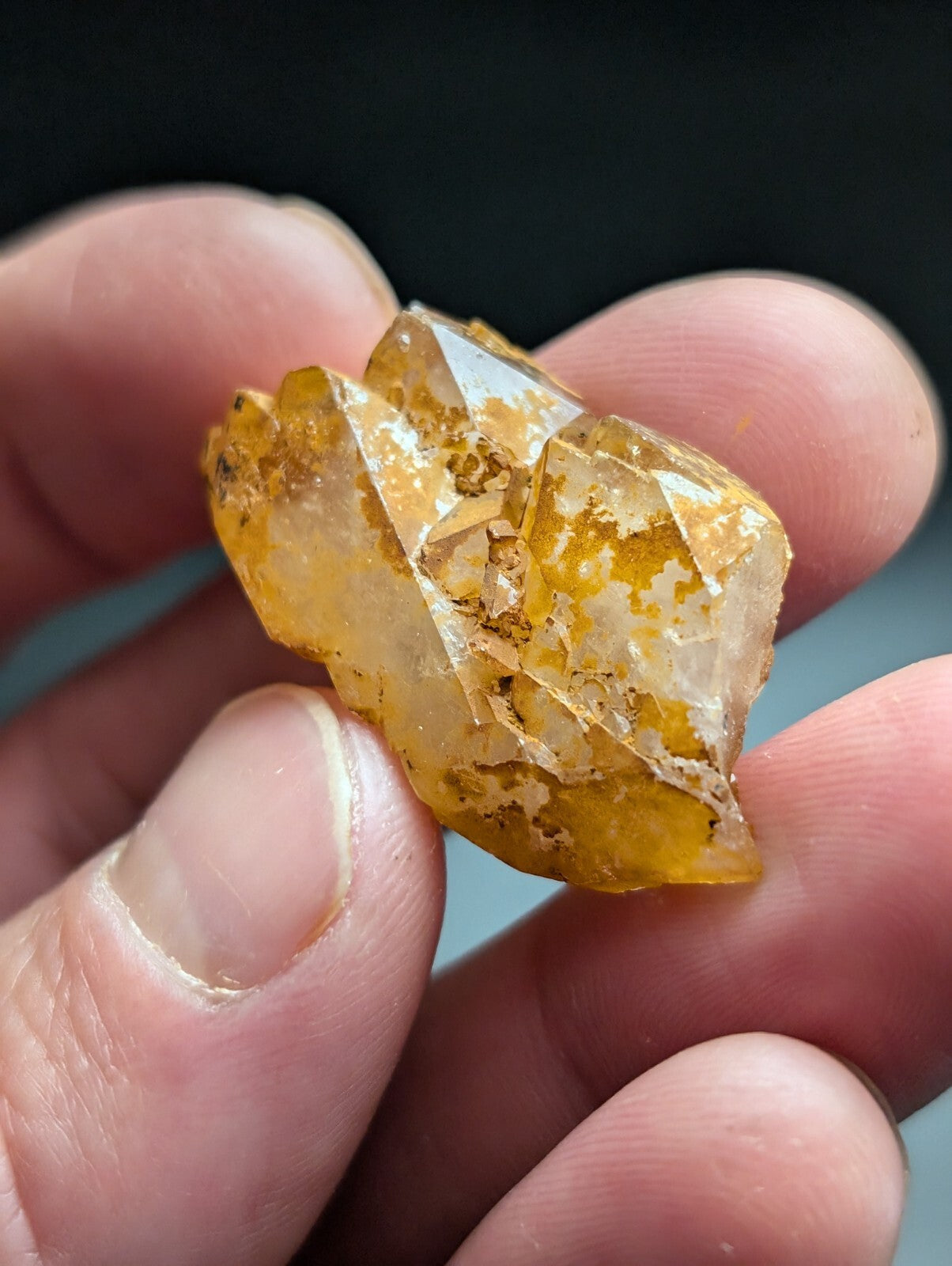 A translucent golden-yellow crystal with sharp, angular facets and embedded brown mineral inclusions.
