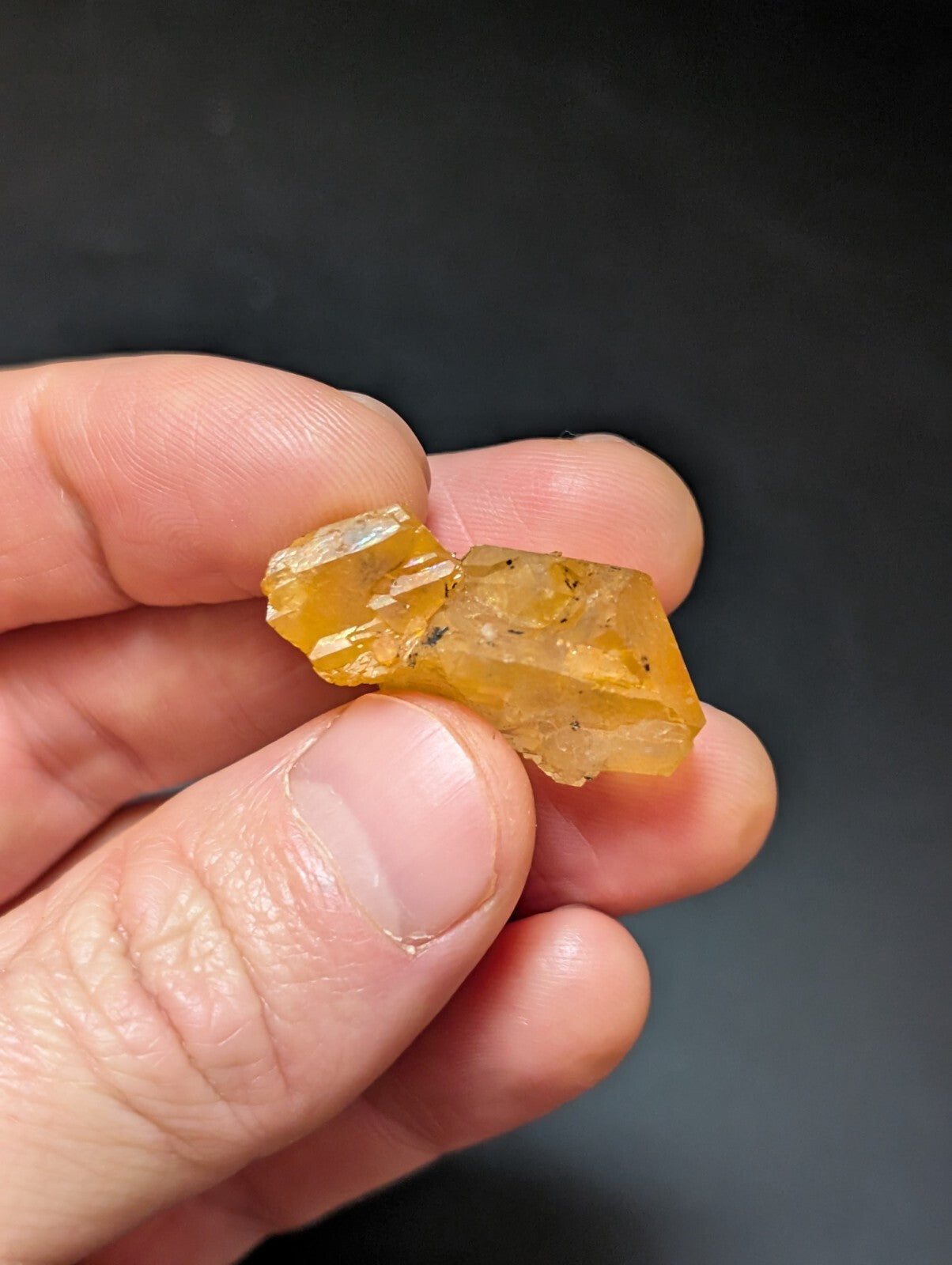 A translucent amber-colored mineral specimen with visible crystalline facets and subtle internal inclusions.