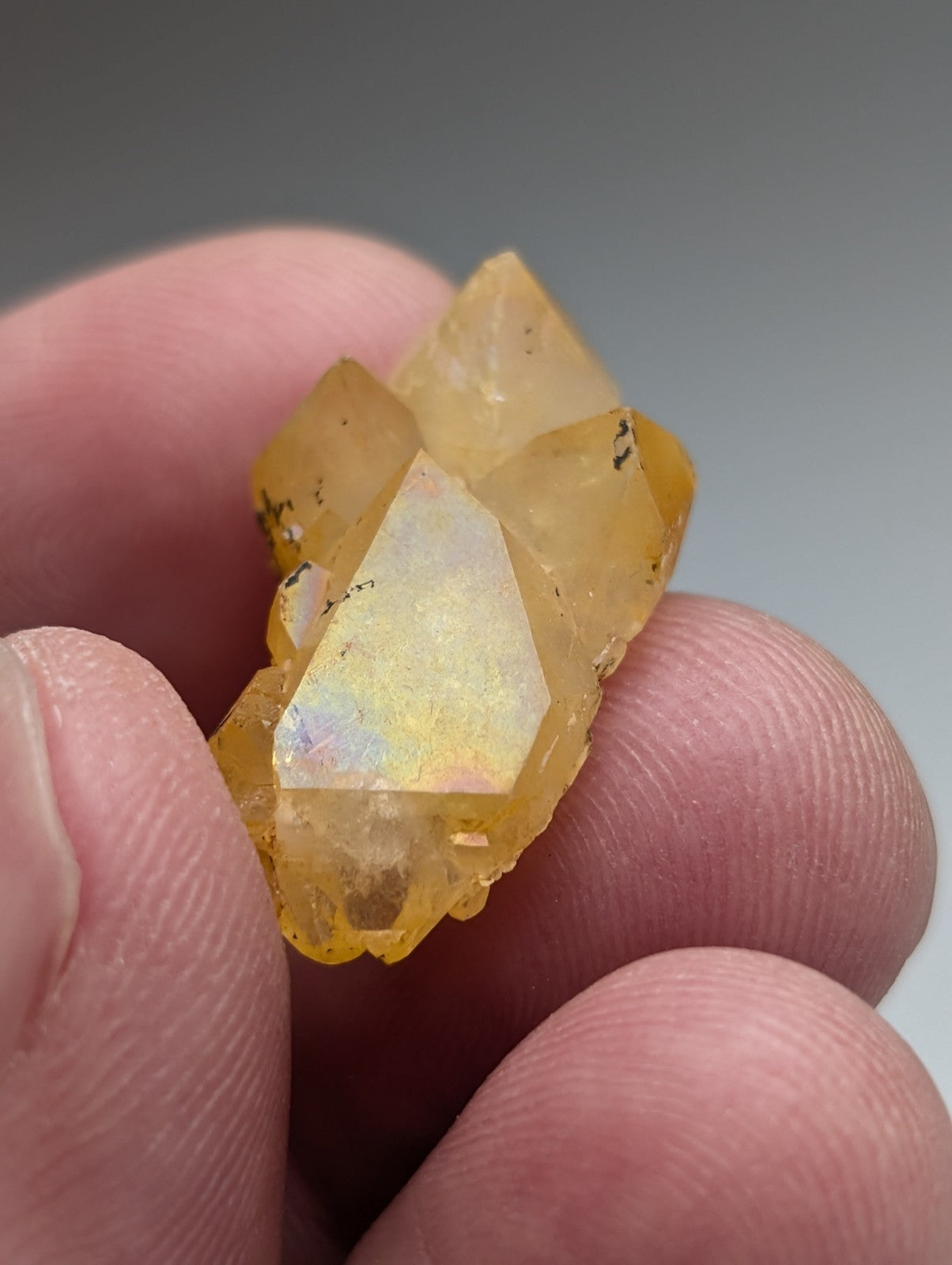 A translucent yellow opal quartz crystal cluster with faceted geometric structure and subtle natural iridescence