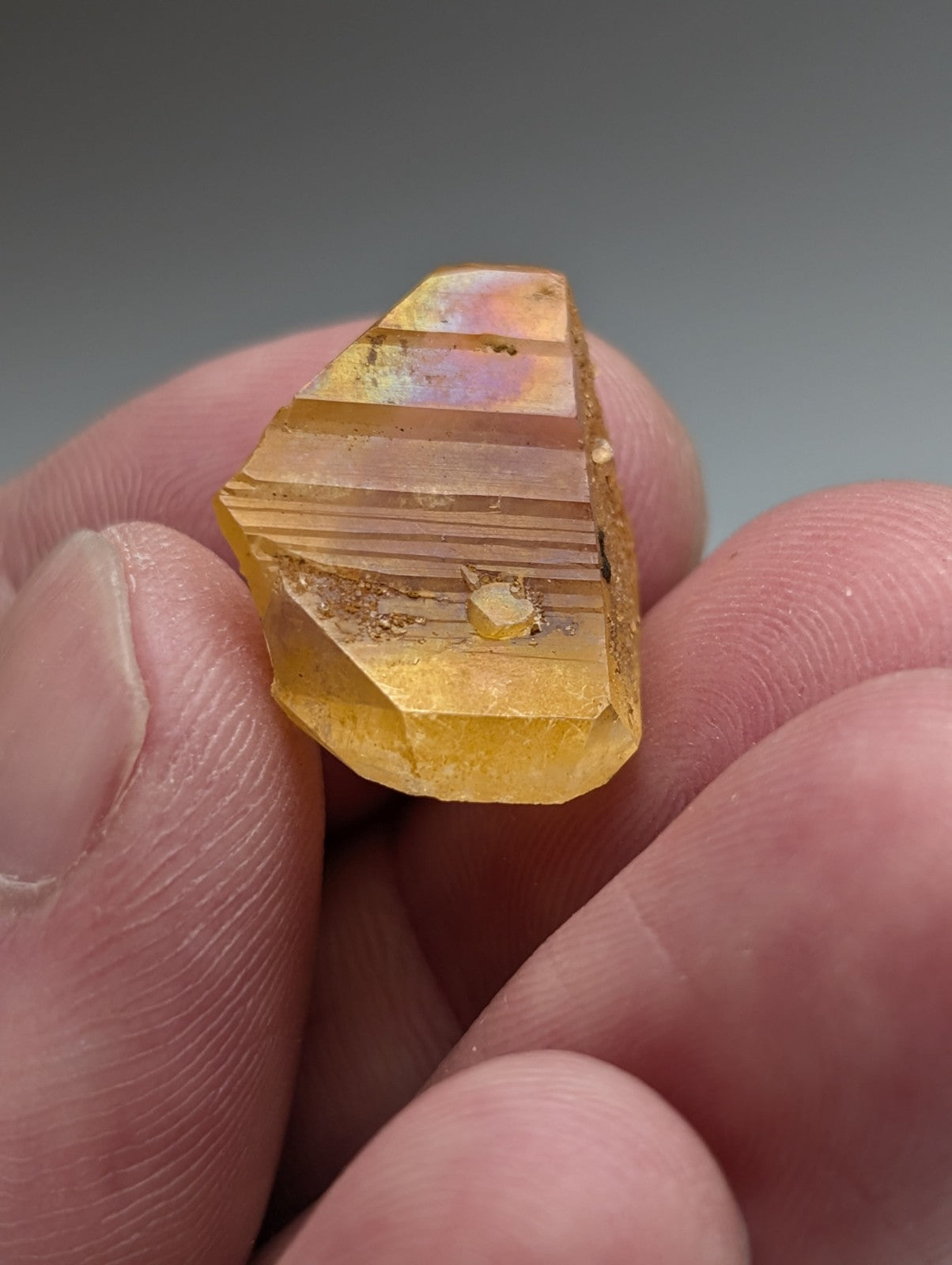 A golden-yellow faceted citrine crystal with natural iridescence and striations from a set of 6 Arkansas quartz crystals