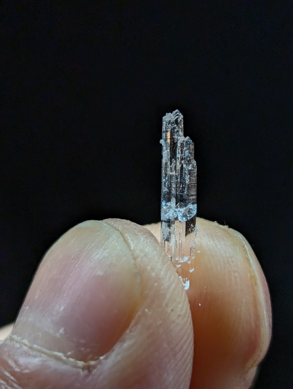 A translucent, clear quartz crystal with a pointed tip and visible internal inclusions.
