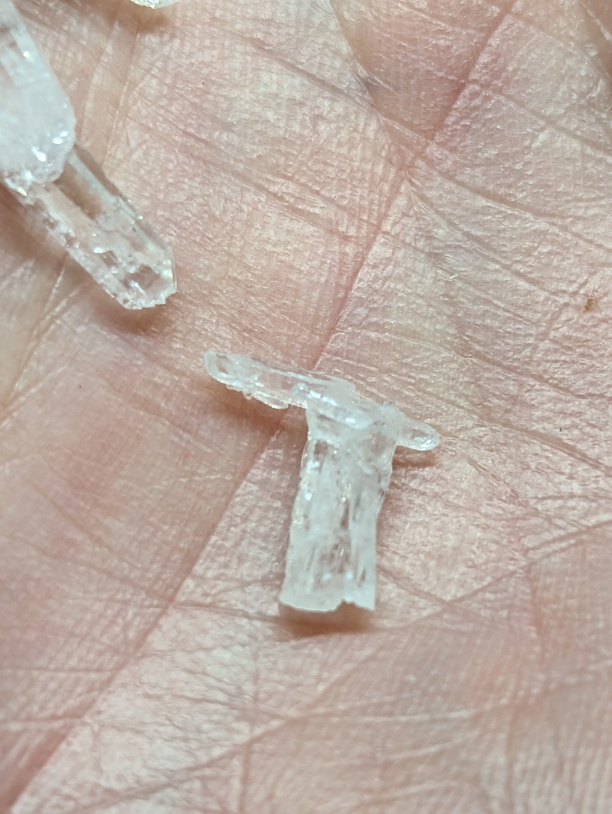 Clear, translucent crystal fragments with jagged edges and natural facets.