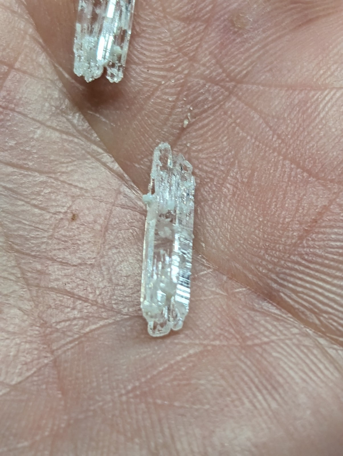 Clear, translucent quartz crystal fragments with visible internal striations and jagged edges.