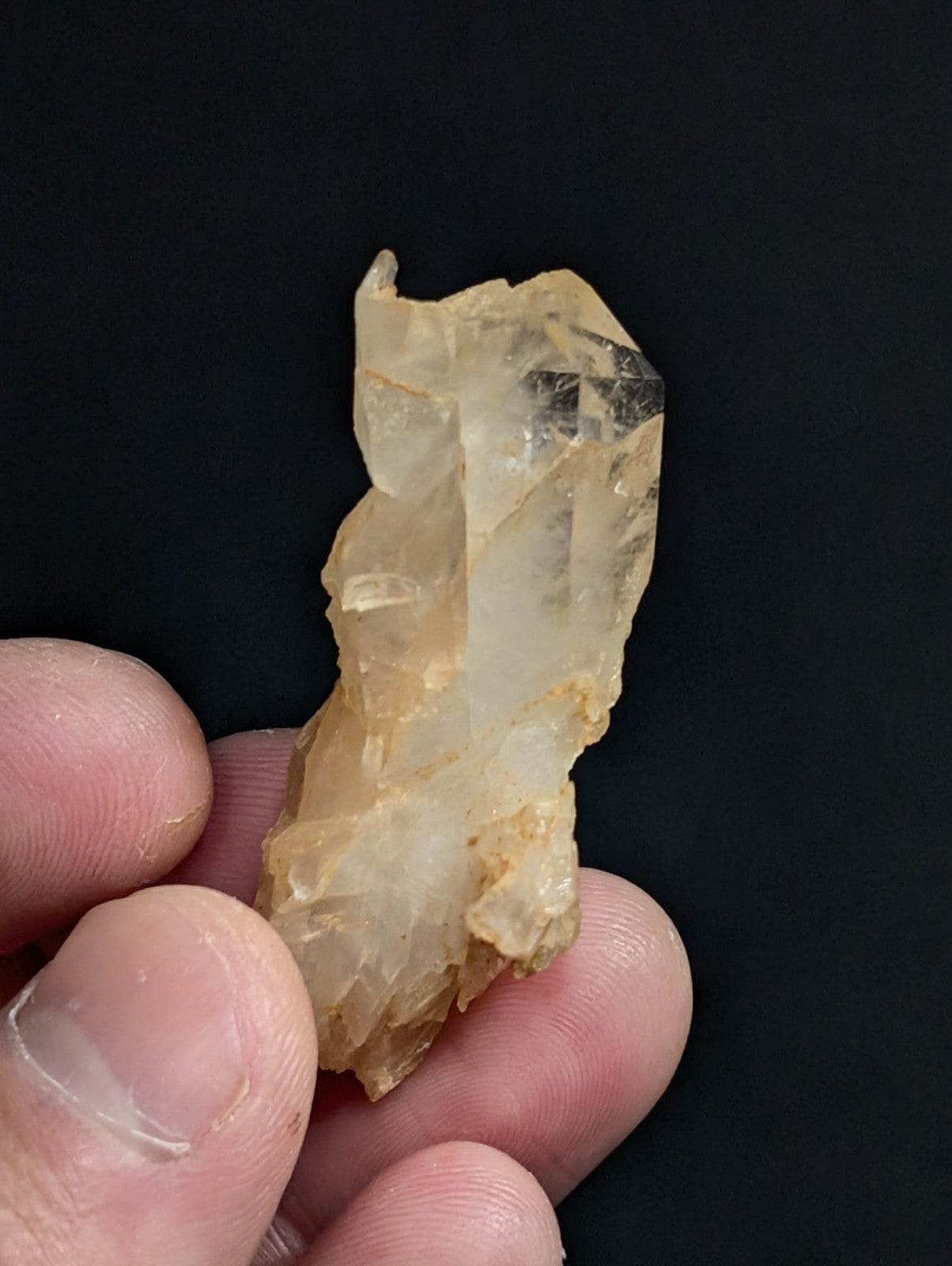 A translucent, pale yellow crystal cluster with jagged edges and a natural, earthy appearance.