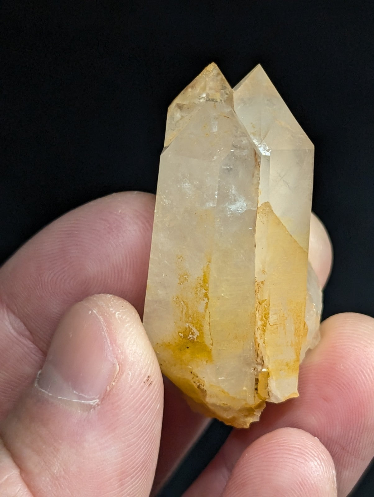 A translucent yellowish quartz crystal with a dual-pronged, faceted structure and natural mineral inclusions.