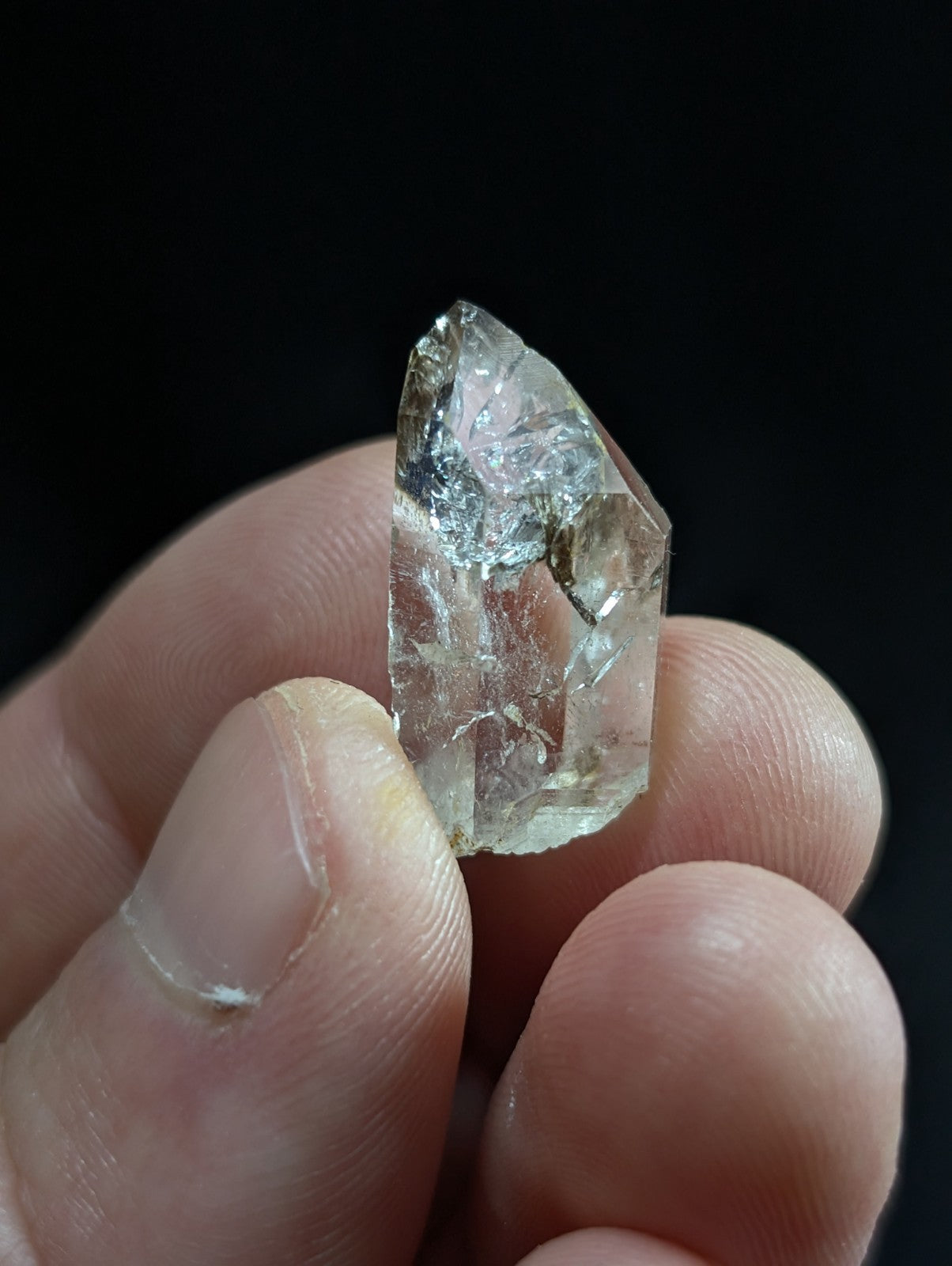 A translucent, clear quartz crystal with a pointed tip and visible internal inclusions.