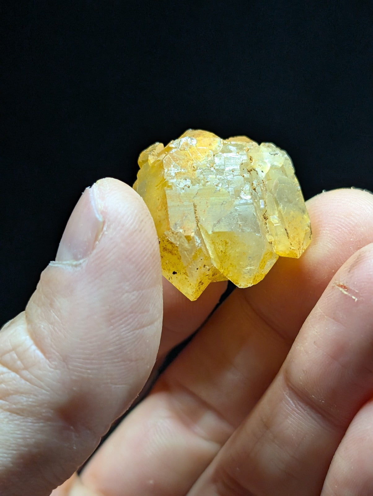 A translucent yellow crystal cluster with sharp, faceted edges and a slightly cloudy appearance.