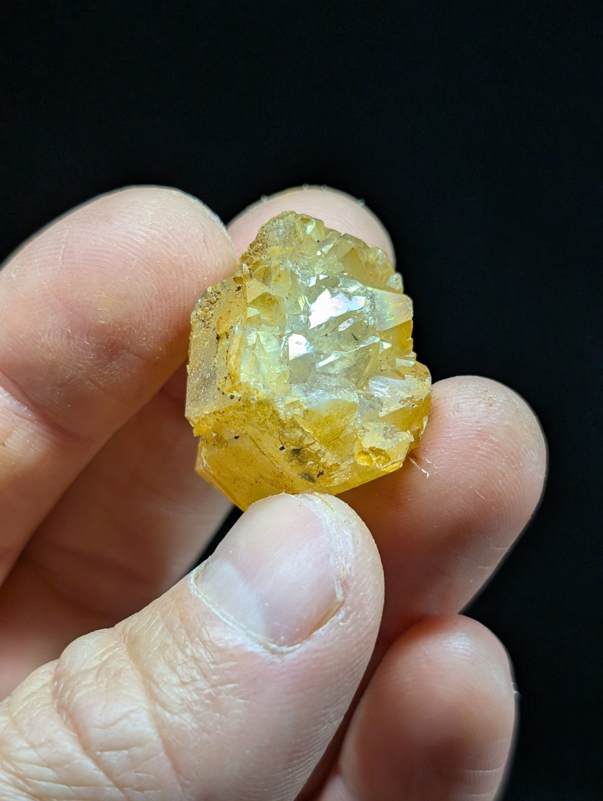 A translucent yellow crystal with a faceted, geometric structure and subtle internal inclusions.