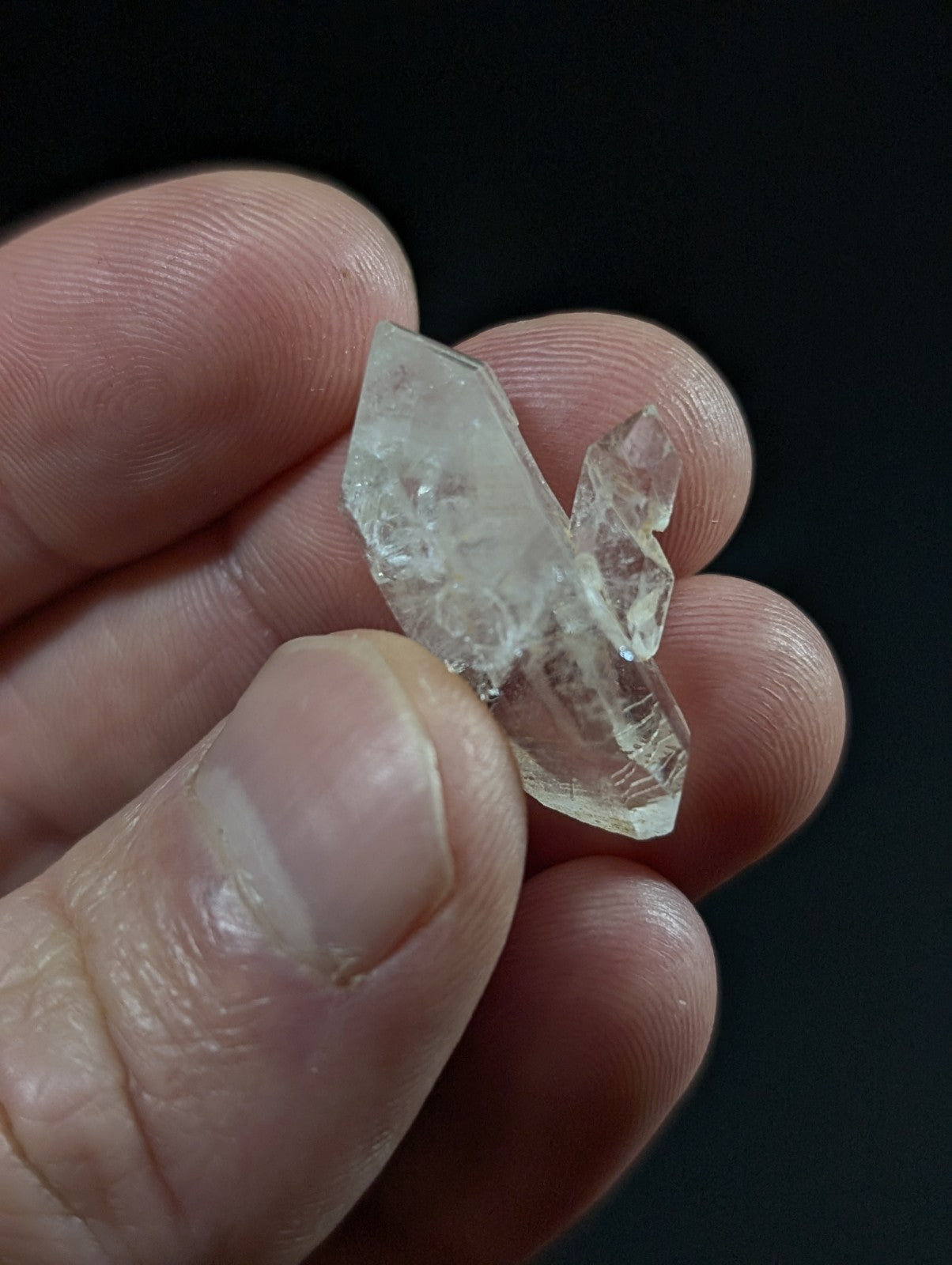 A translucent, clear quartz crystal cluster with sharp geometric facets and a slightly cloudy interior.