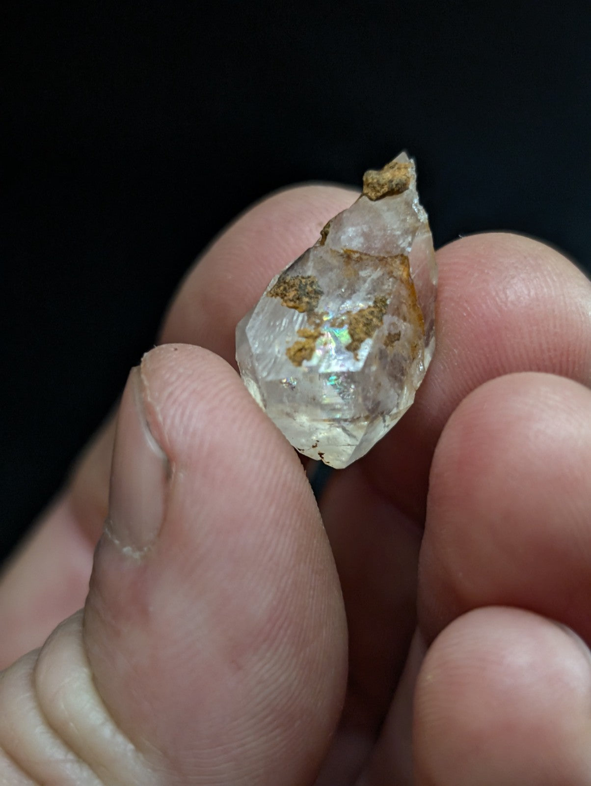 A translucent, faceted quartz crystal with golden mineral inclusions.