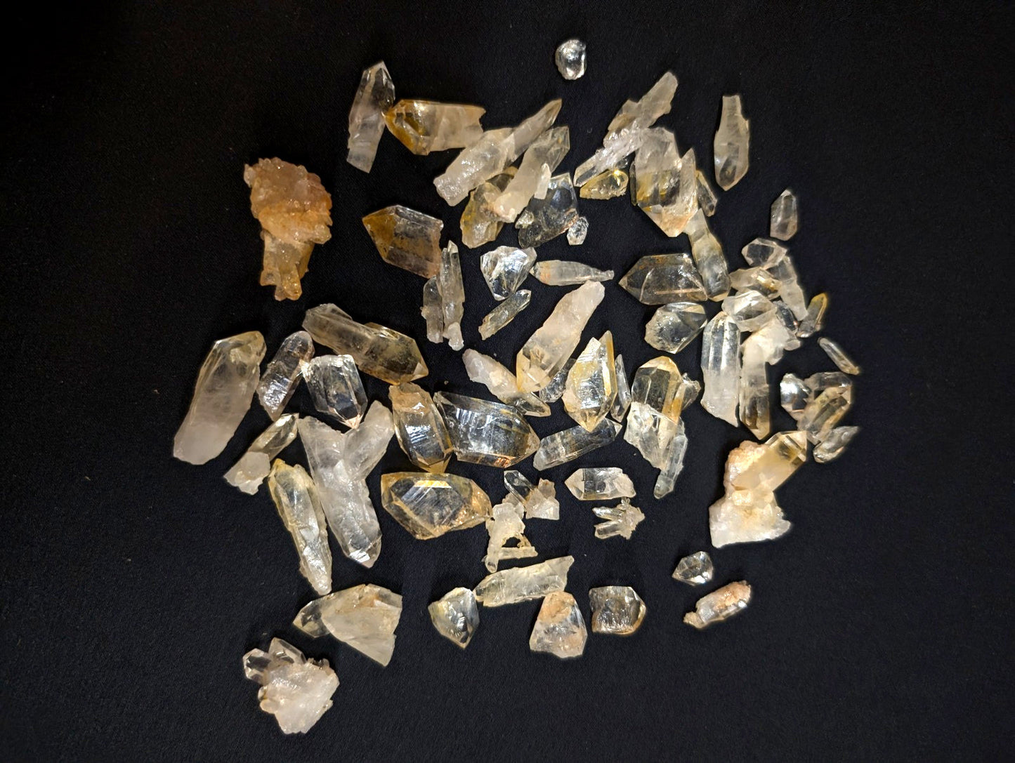 A collection of clear and golden-yellow quartz crystals with sharp, faceted edges.