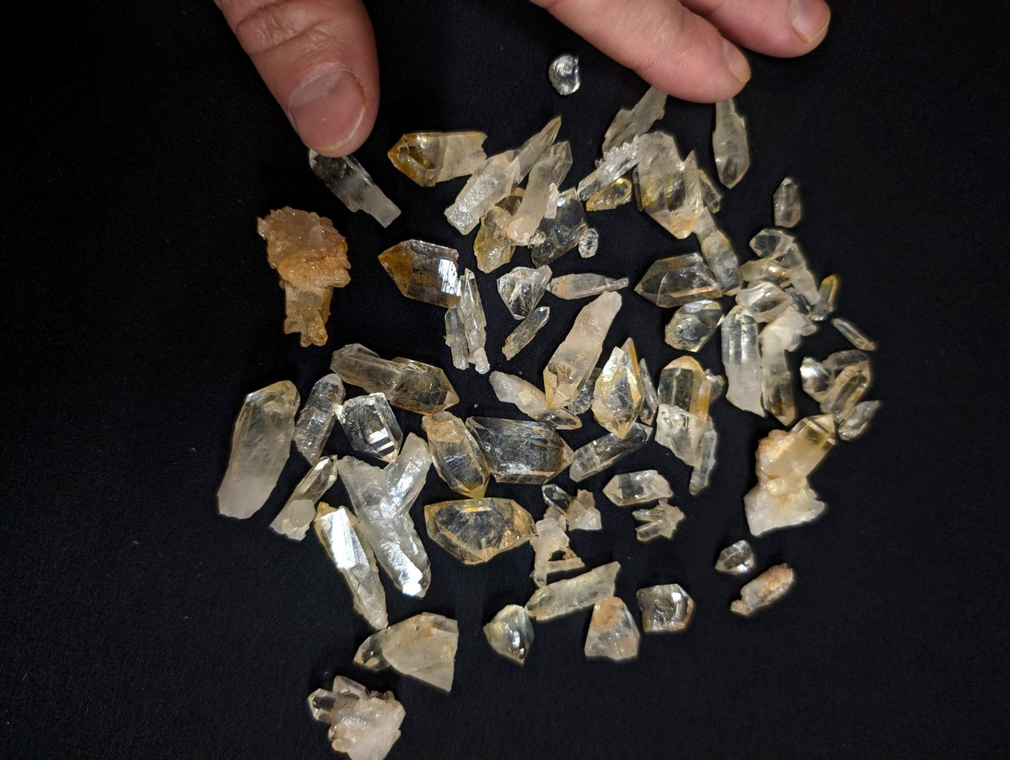 A collection of clear and golden-yellow quartz crystals with jagged, faceted edges.