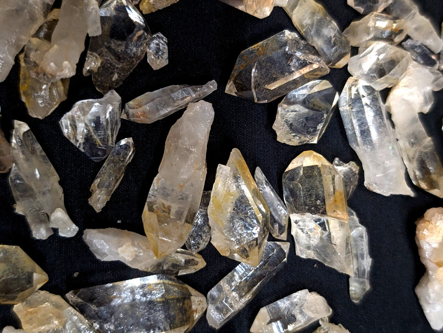 Clear quartz crystals with golden inclusions and sharp, faceted edges.
