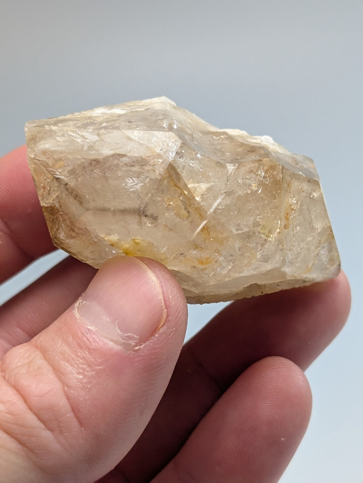 A translucent yellowish quartz crystal with visible internal inclusions and a rough, faceted surface.