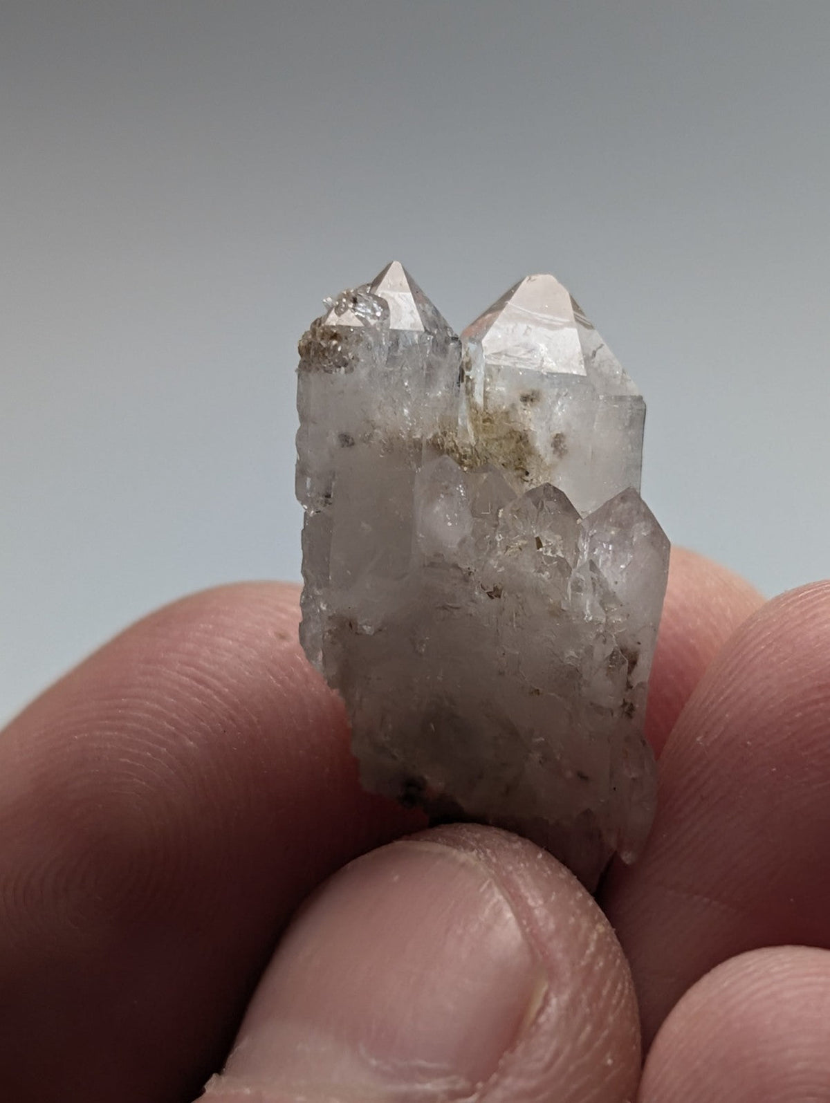A translucent, clear quartz crystal cluster with pointed terminations and subtle internal inclusions.