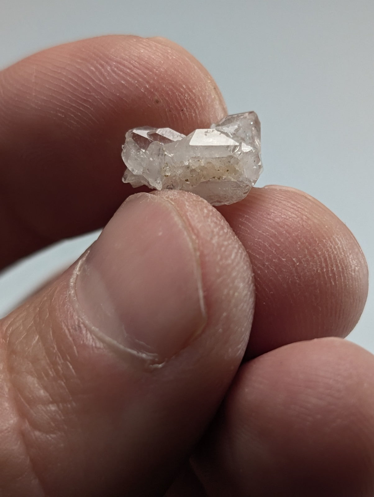 A translucent, clear quartz crystal cluster with a rough, jagged surface and subtle internal inclusions.