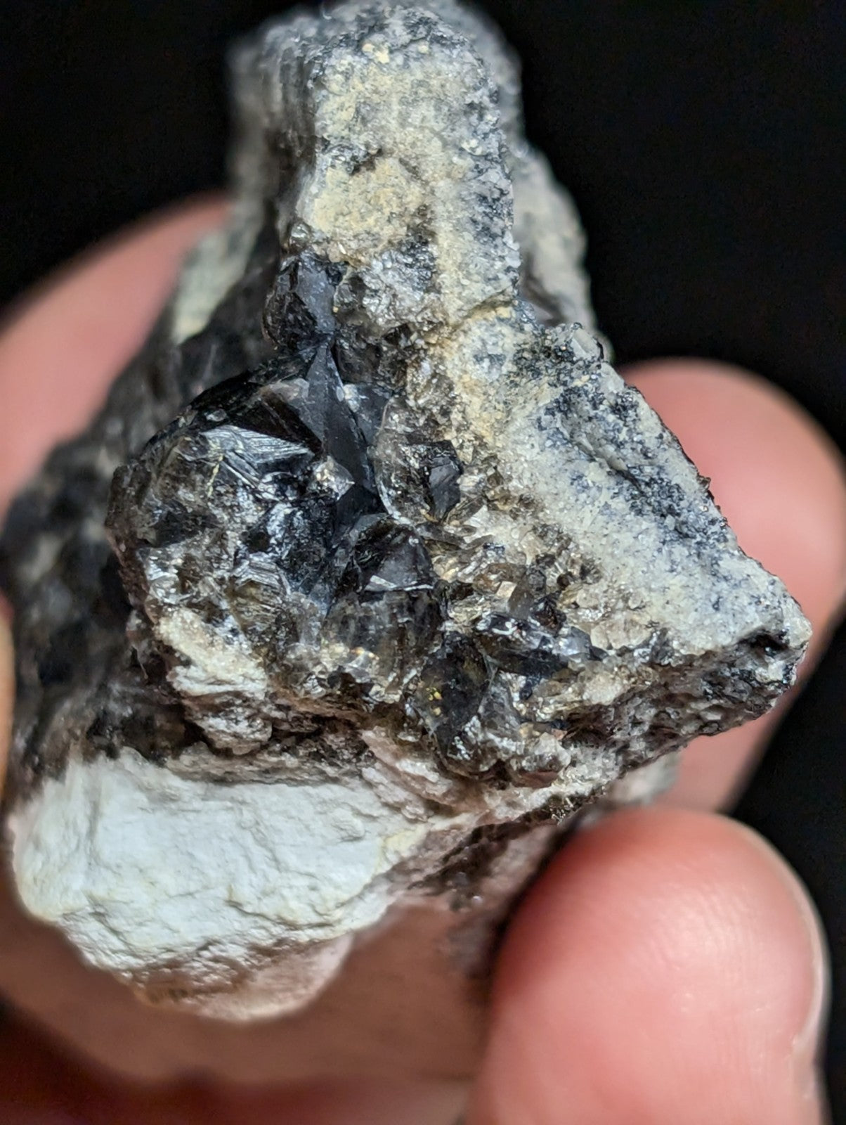 A rough, irregularly shaped mineral specimen featuring a dark, crystalline core embedded in a lighter gray matrix.