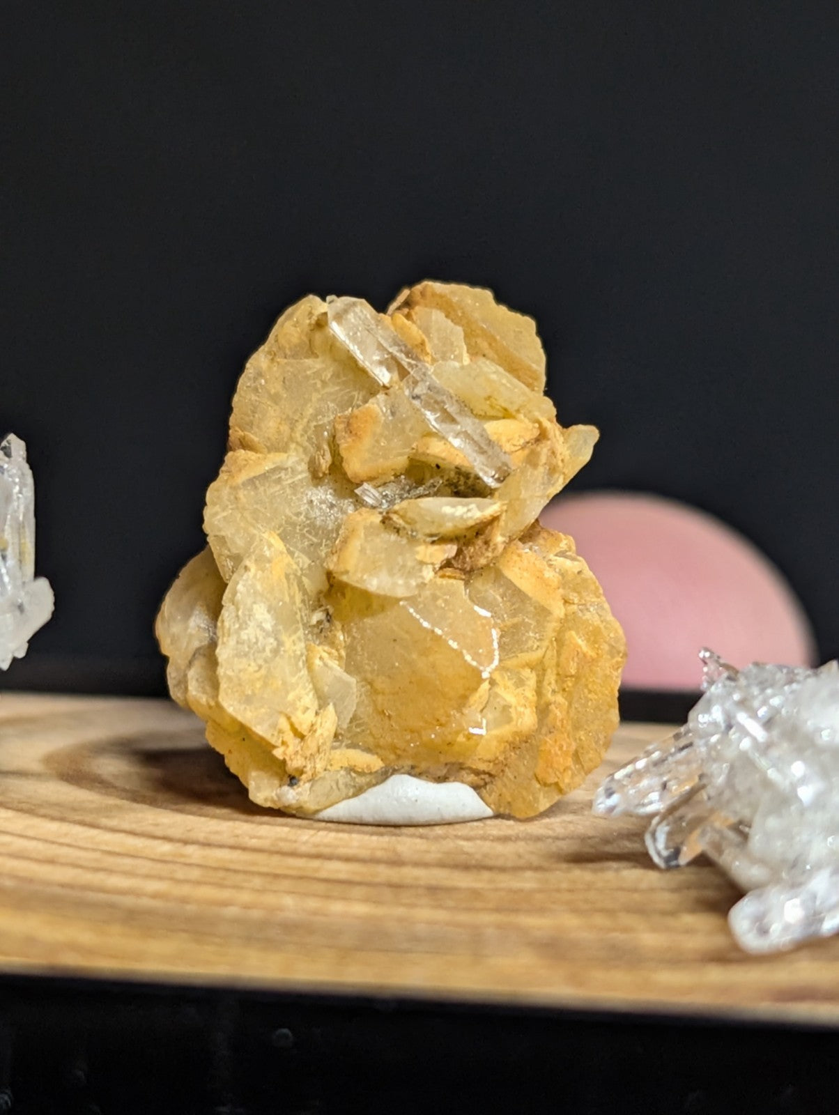 A translucent yellowish crystal cluster with clear quartz points emerging from a rough, earthy base.