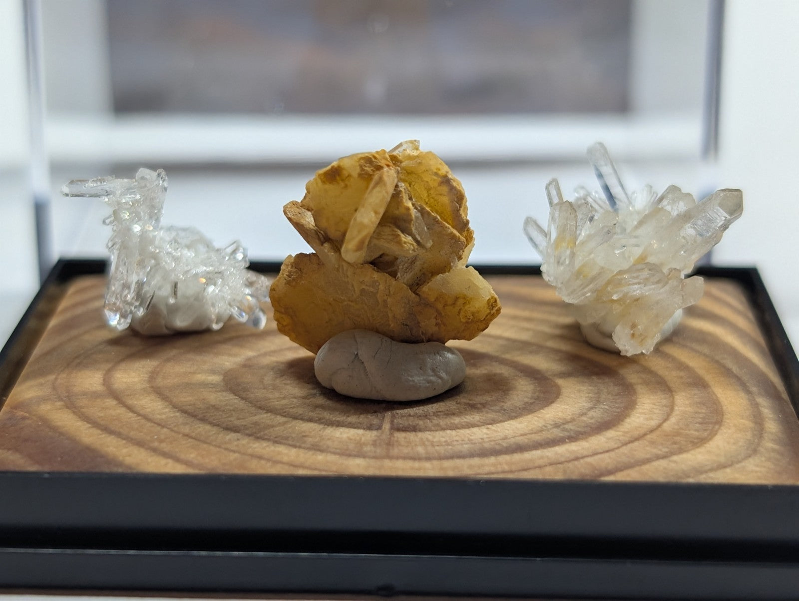 Golden mineral specimen with translucent crystal formations resting on a smooth gray stone base.