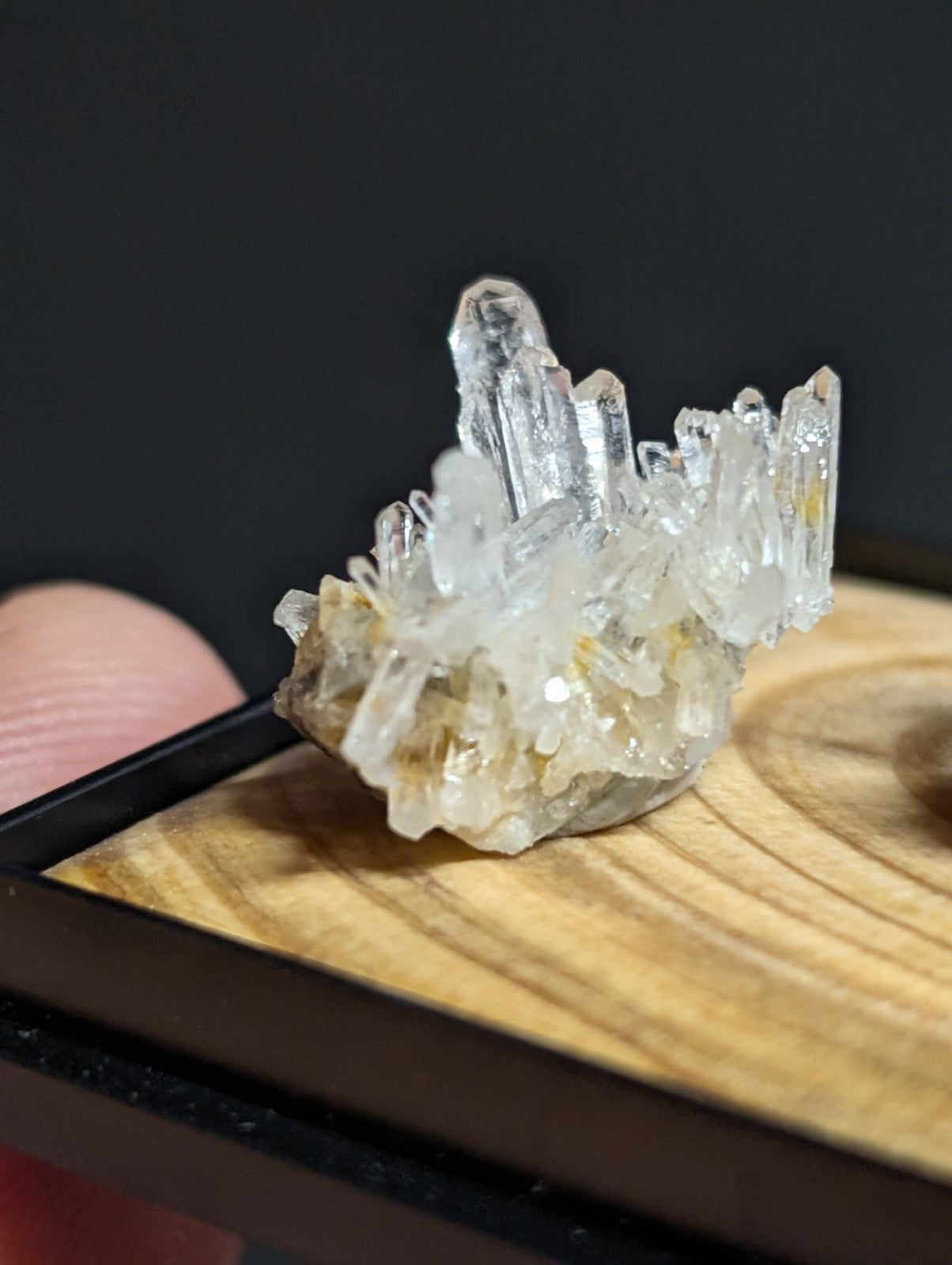 A clear quartz crystal cluster with translucent, pointed formations and subtle yellowish hues.