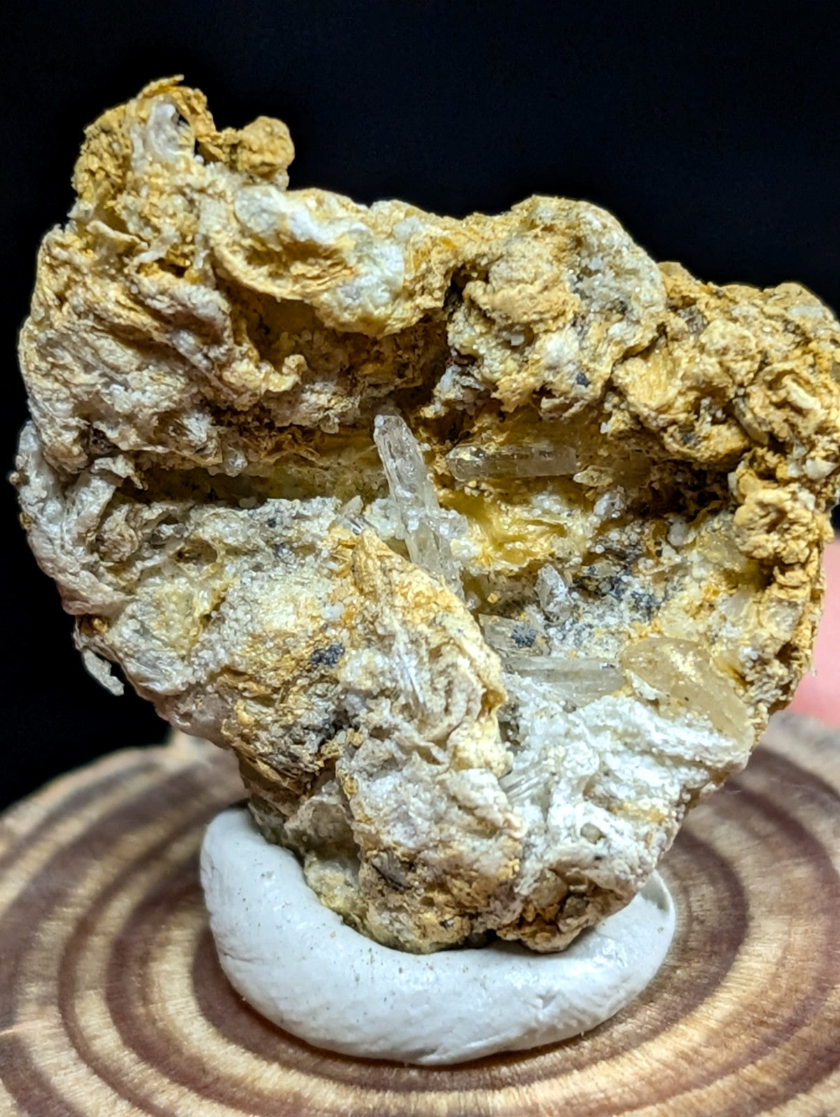 A rugged, naturally formed mineral specimen with a textured surface of yellowish-brown and white crystalline formations.