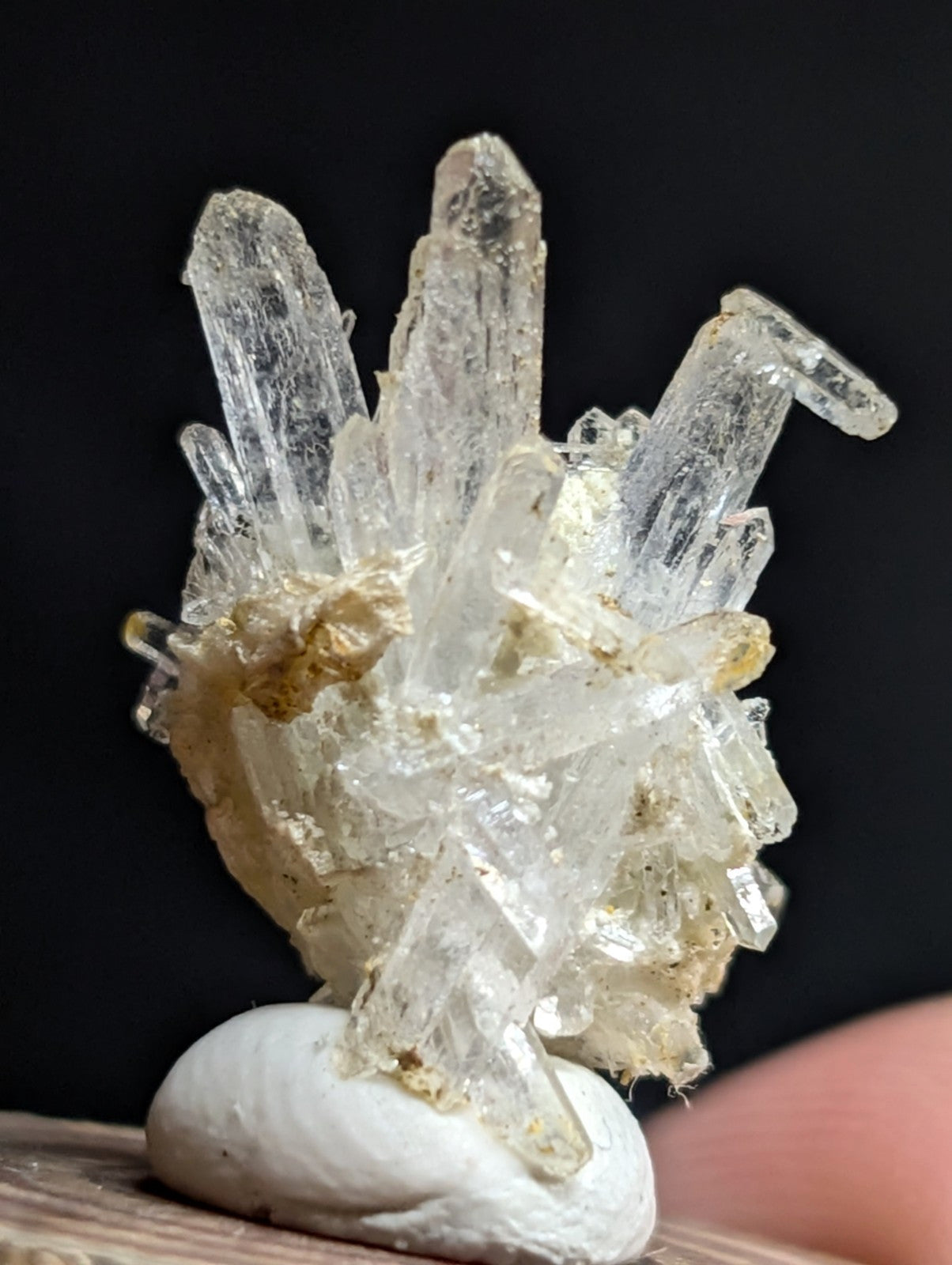 A translucent, clear quartz crystal cluster with sharp, pointed formations and a natural matrix base.